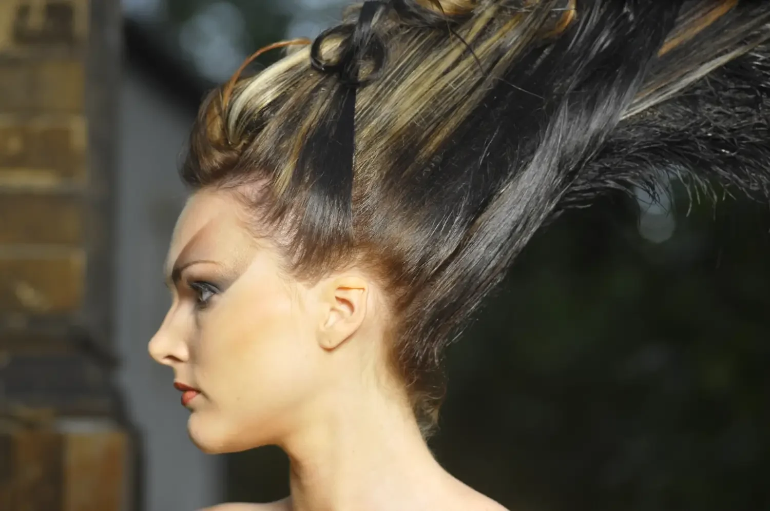 Profilaufnahme mit skulpturaler Avantgarde-Frisur und modernem Editorial-Beauty-Look.