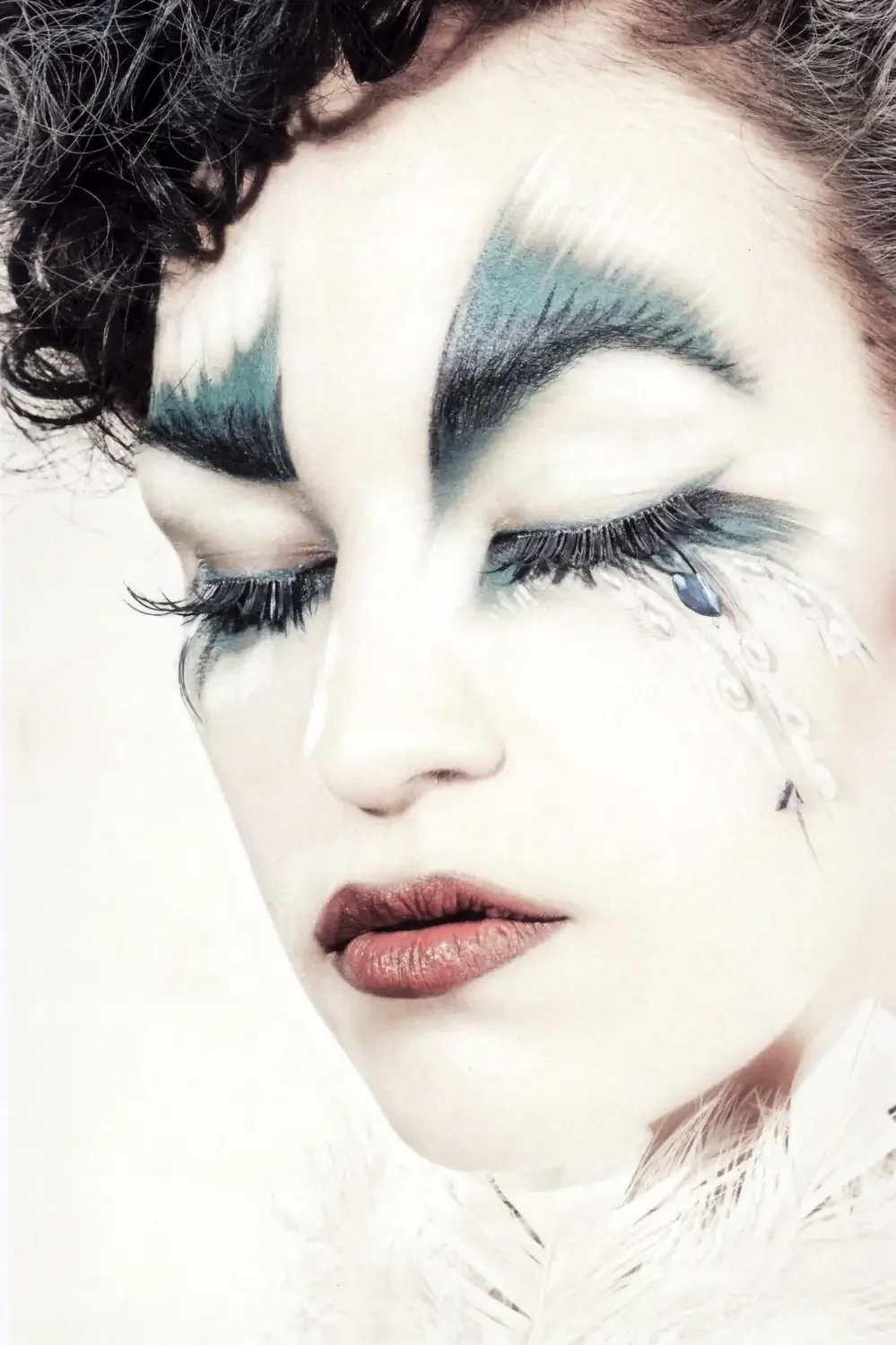 Close-up mit künstlerischem Feder-Make-up, langen Wimpern und avantgardistischem Beauty-Styling.