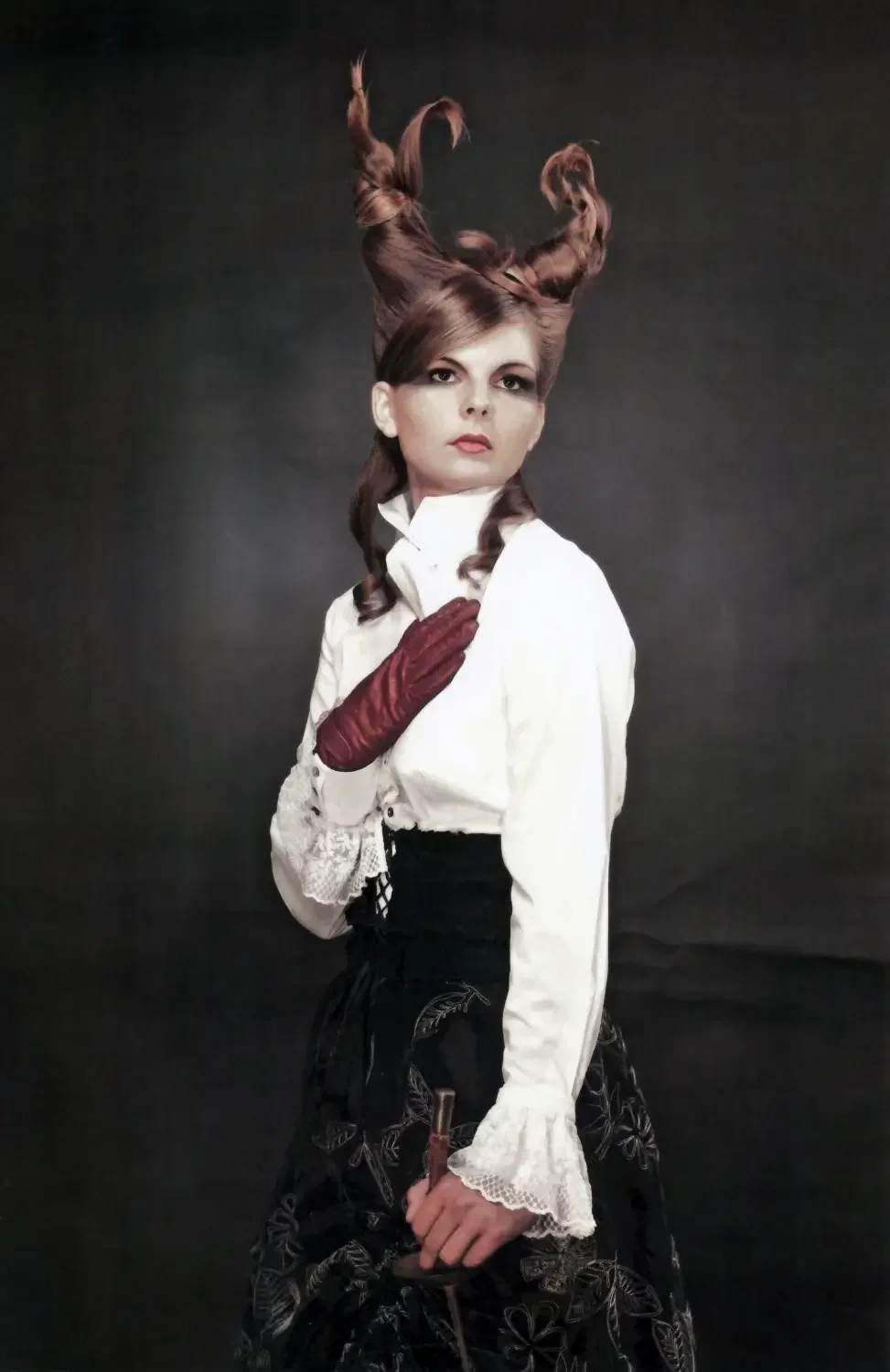 Editorial-Porträt mit skulpturaler Hochsteckfrisur, viktorianischer Mode und dramatischem Beauty-Look.