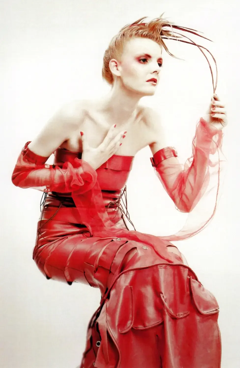 Avantgardistisches Fashion-Porträt in Rot mit kreativem Editorial-Make-up und skulpturalem Hairstyling.