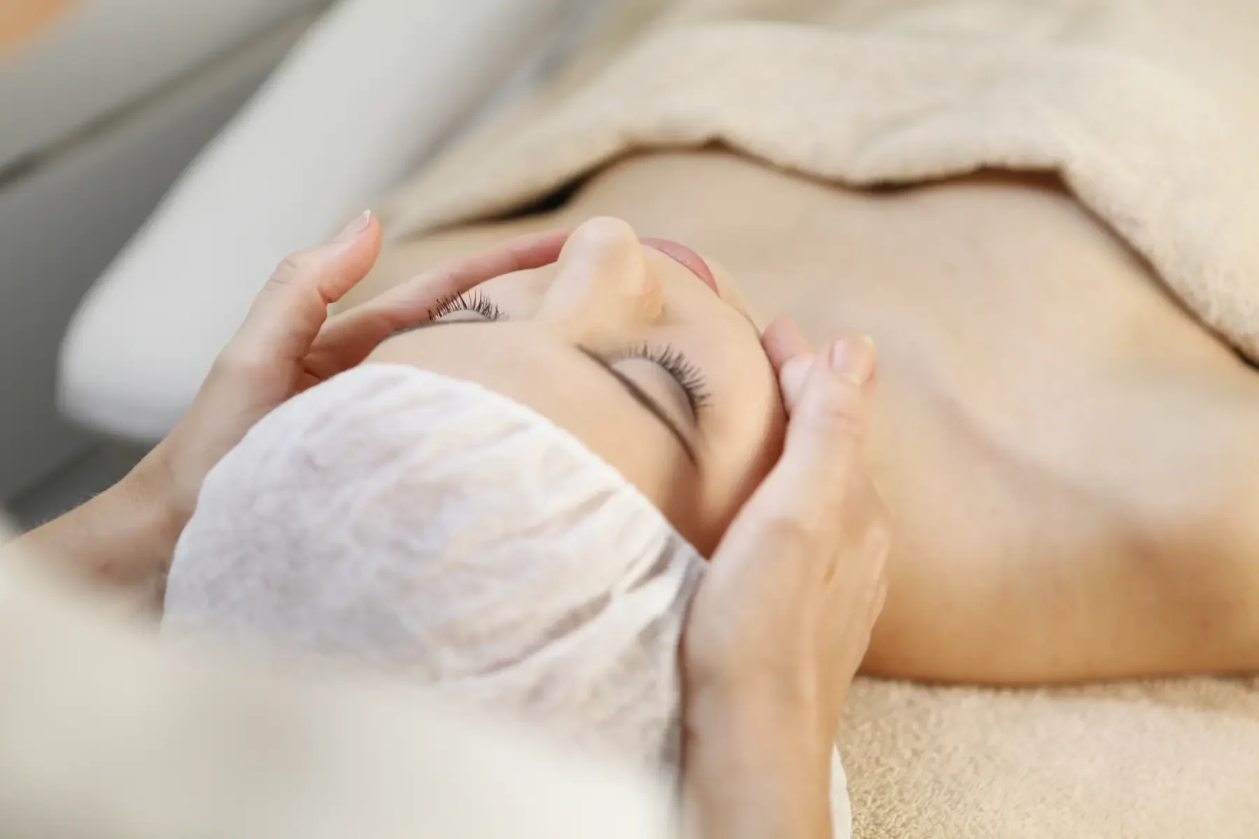 Kosmetische Gesichtsbehandlung mit entspannender Kopf- und Gesichtsmassage während einer professionellen Hautpflegeanwendung bei Garzareck Cosmetics in Halle (Saale).