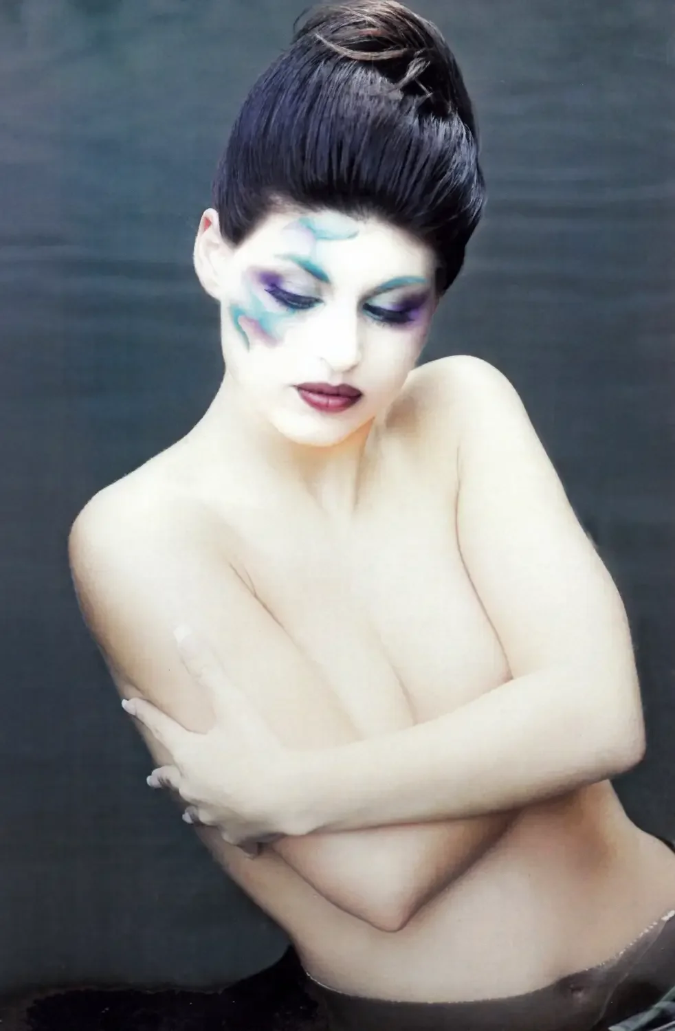 Künstlerisches Beauty-Porträt mit farbigem Editorial-Make-up, elegantem Hochstecklook und weicher Studioästhetik.