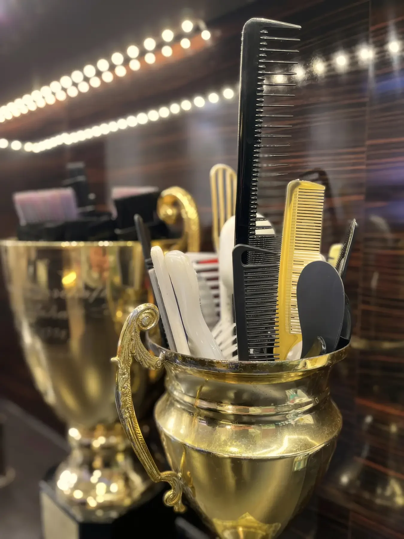 Kämme und Friseurwerkzeuge werden bei Garzareck Coiffeur & Cosmetics in Halle (Saale) in historischen Siegerpokalen aufbewahrt – ein charakteristisches Detail des Salons.