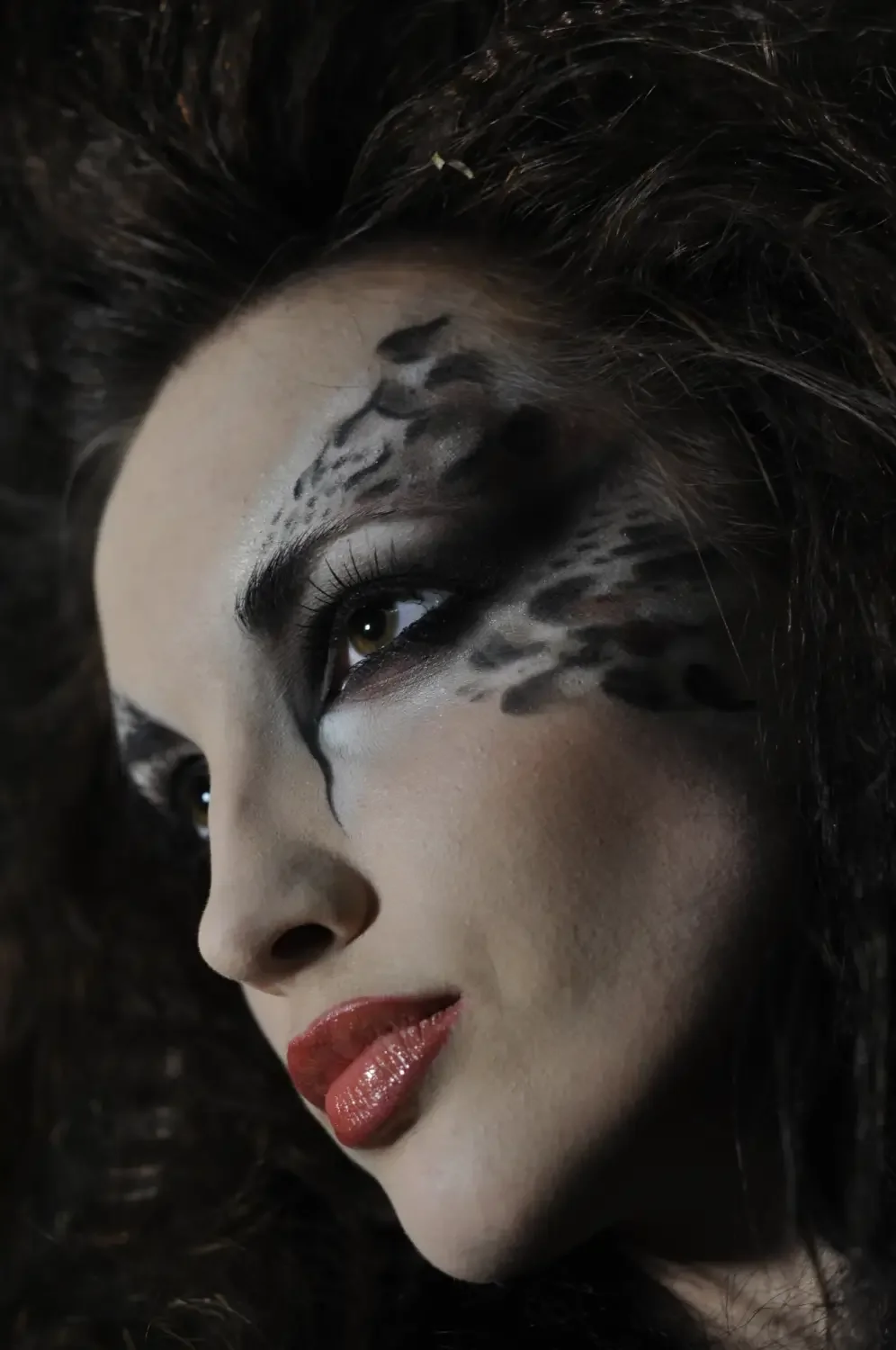 Dunkles Beauty-Porträt mit animalisch inspiriertem Editorial-Make-up und intensiver Close-up-Ästhetik.