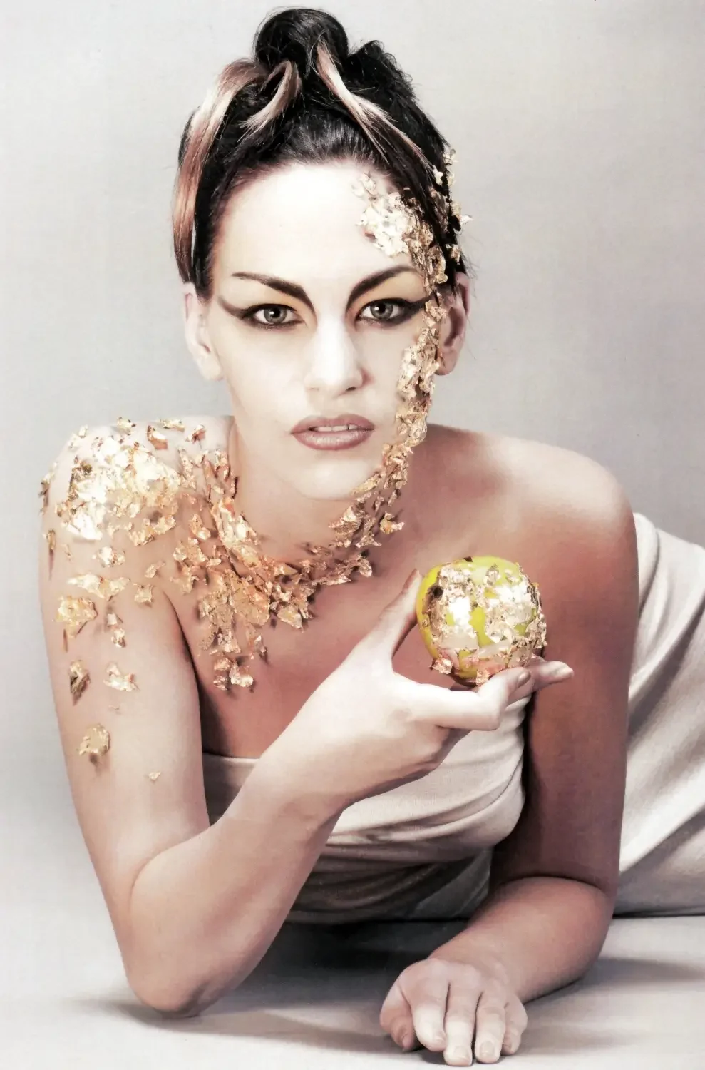 Garzareck „The Art of Make-up“ Editorial mit Goldblatt-Make-up, grafischem Eyeliner und vergoldetem Apfel.