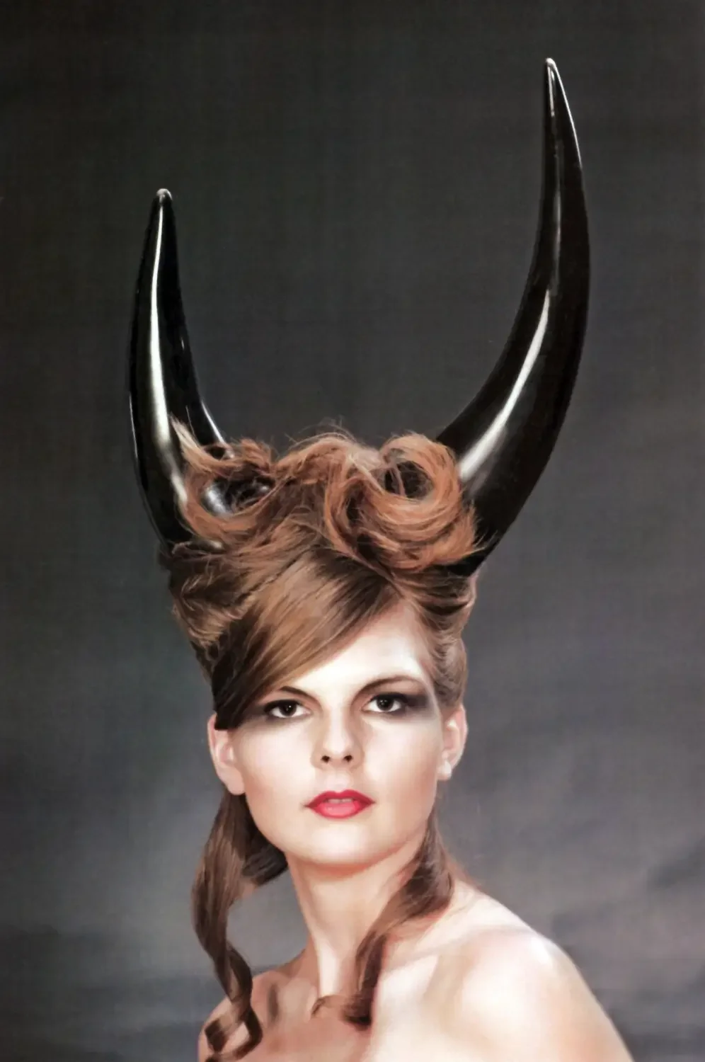 Fantasy-Editorial mit skulpturaler Frisur, schwarzen Hörnern und dramatischem Fashion-Make-up.
