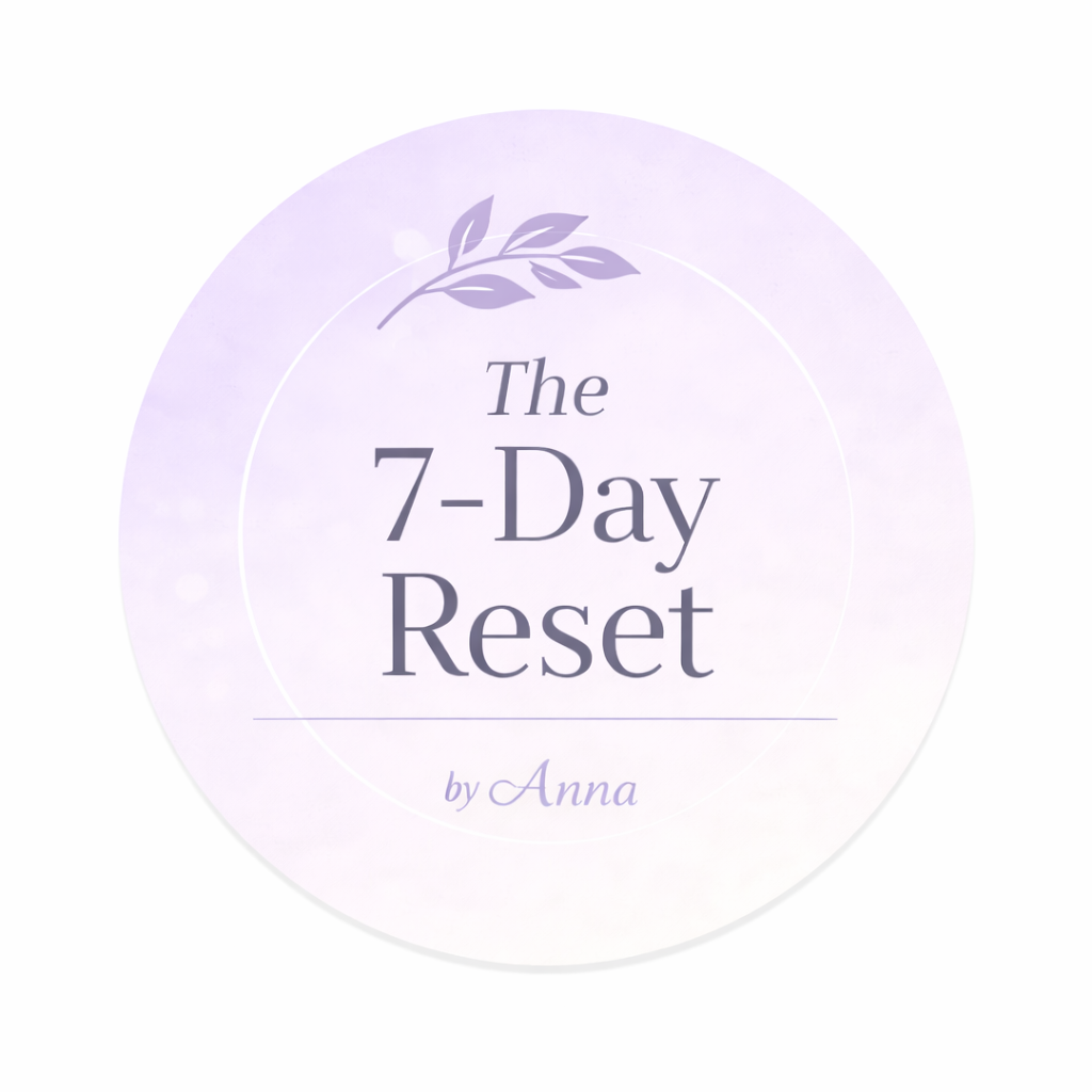 A circular logo with a purple floral design at the top, featuring the text "The 7-Day Reset by Anna" in elegant font on a light purple background.