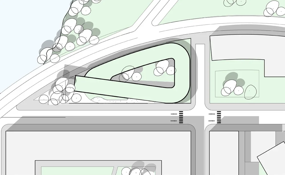 A street map showing a triangular building surrounded by trees, a nearby water body, and crosswalks at an intersection.