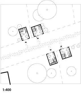 Architectural site plan showing four small buildings with surrounding landscaping, trees, and pathways, at a scale of 1:400.
