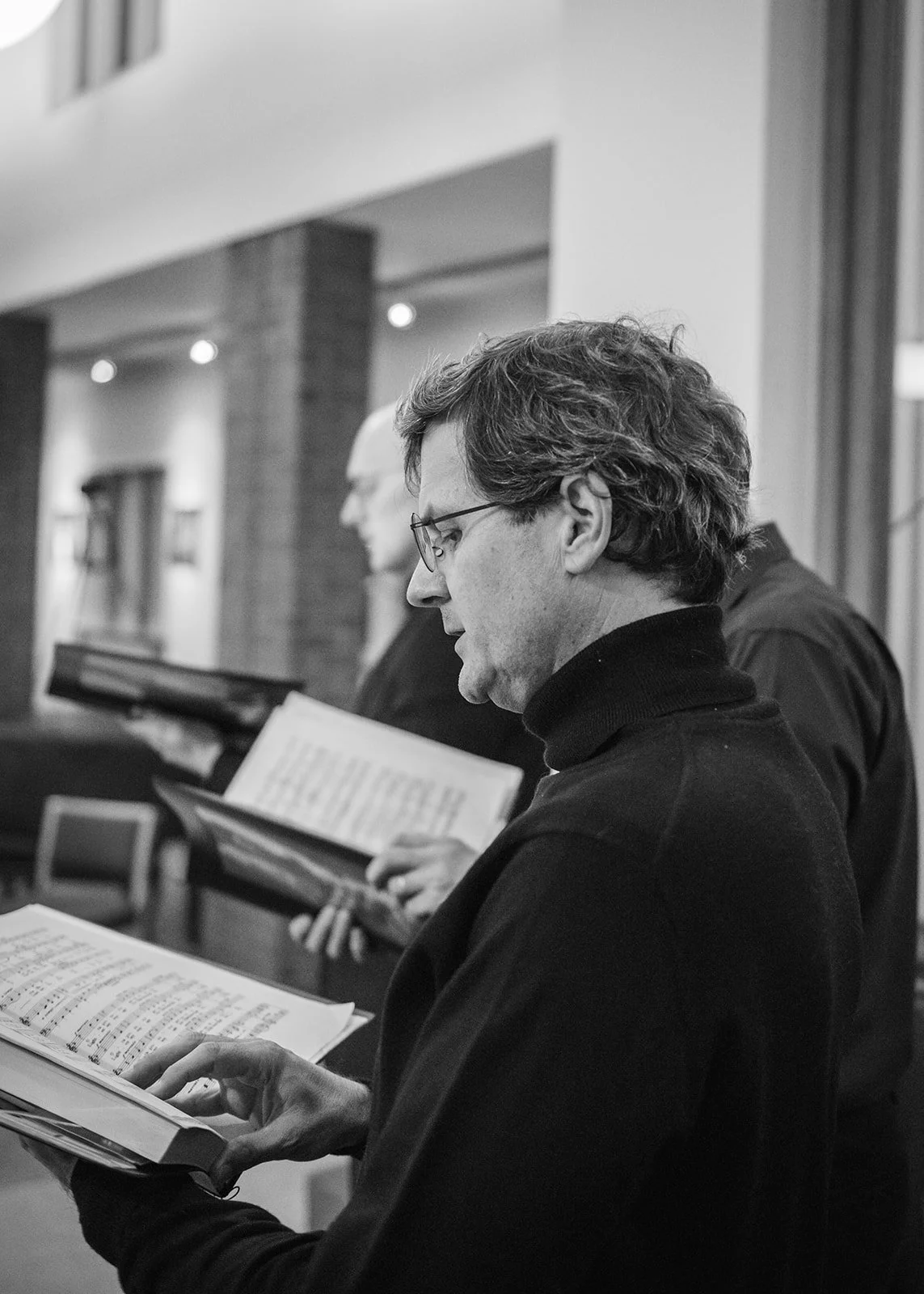 People singing from sheet music in a church.