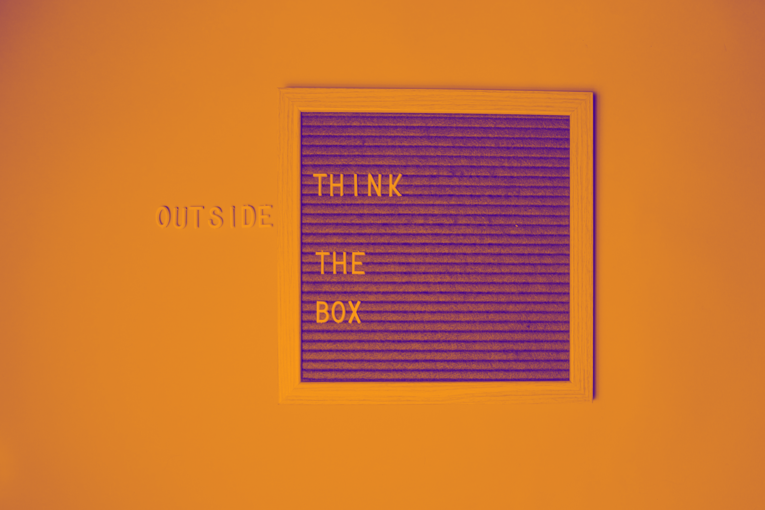 Holztafel mit Buchstaben-Schriftzug „Think outside the box"