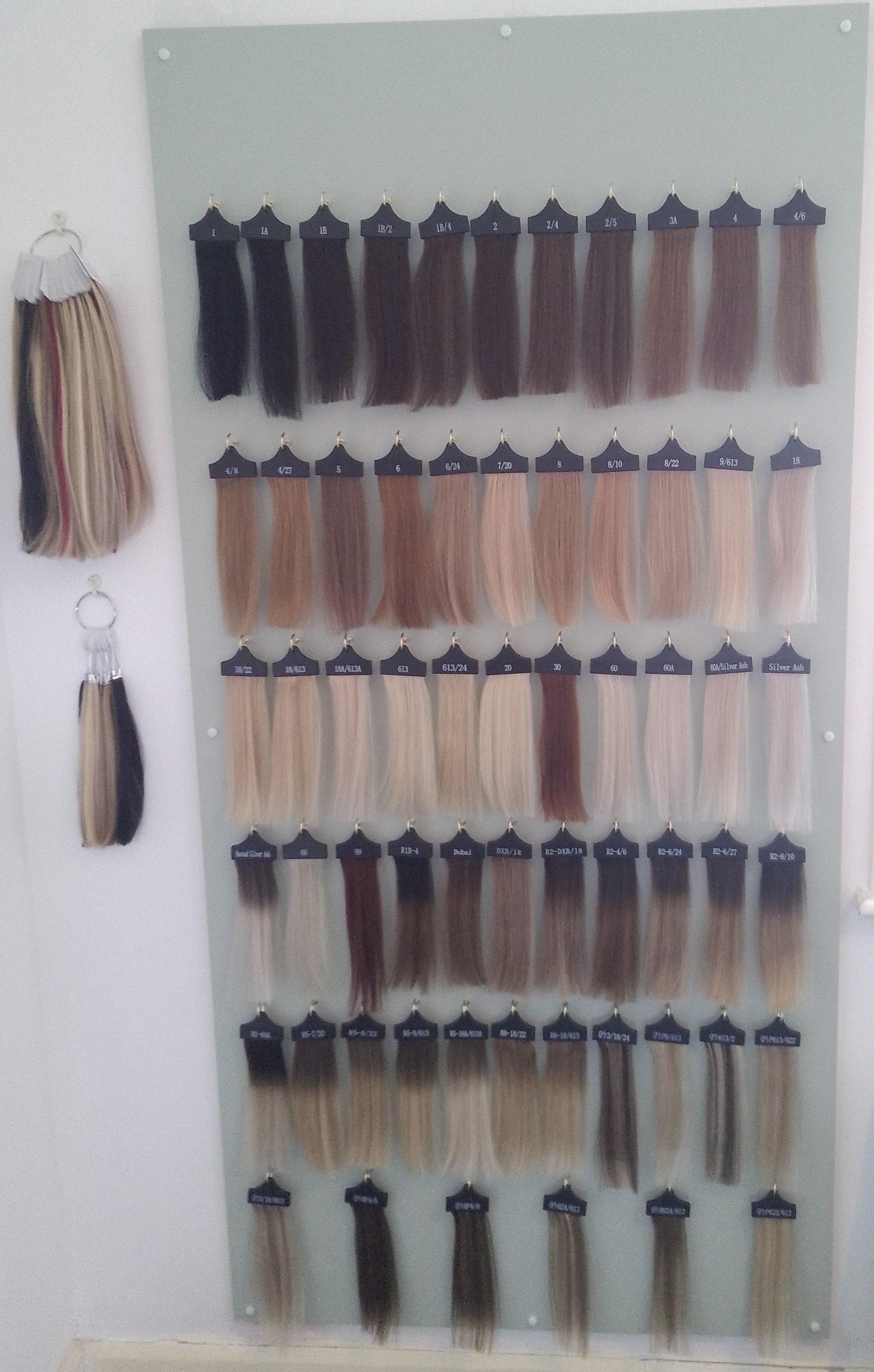 Hair color and highlights sample chart with various hair strands attached in rows, labeled with numbers and color codes.