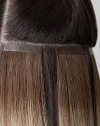 Close-up of hair being colored or treated in a salon, with different shades of brown visible.