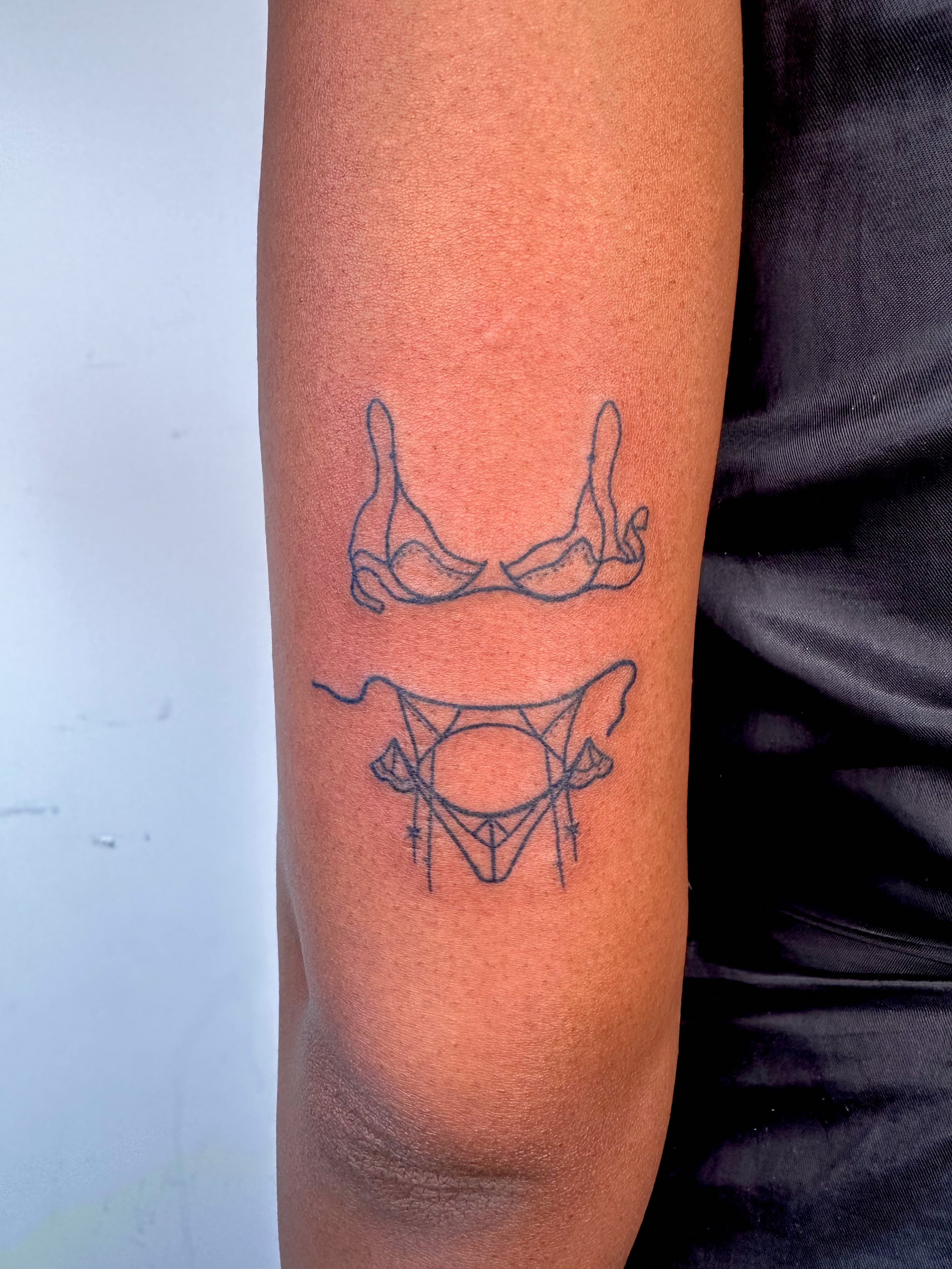 delicate stick and poke hand poke tattoo on back of arm
