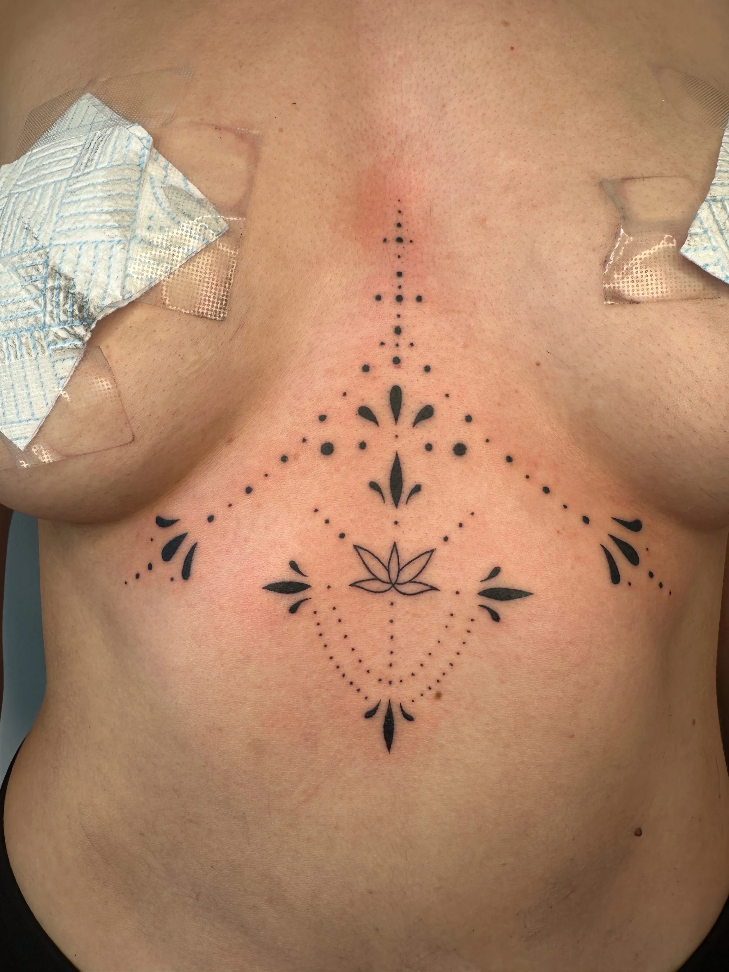 Ornamental delicate hand poke, stick and poke tattoo on sternum 