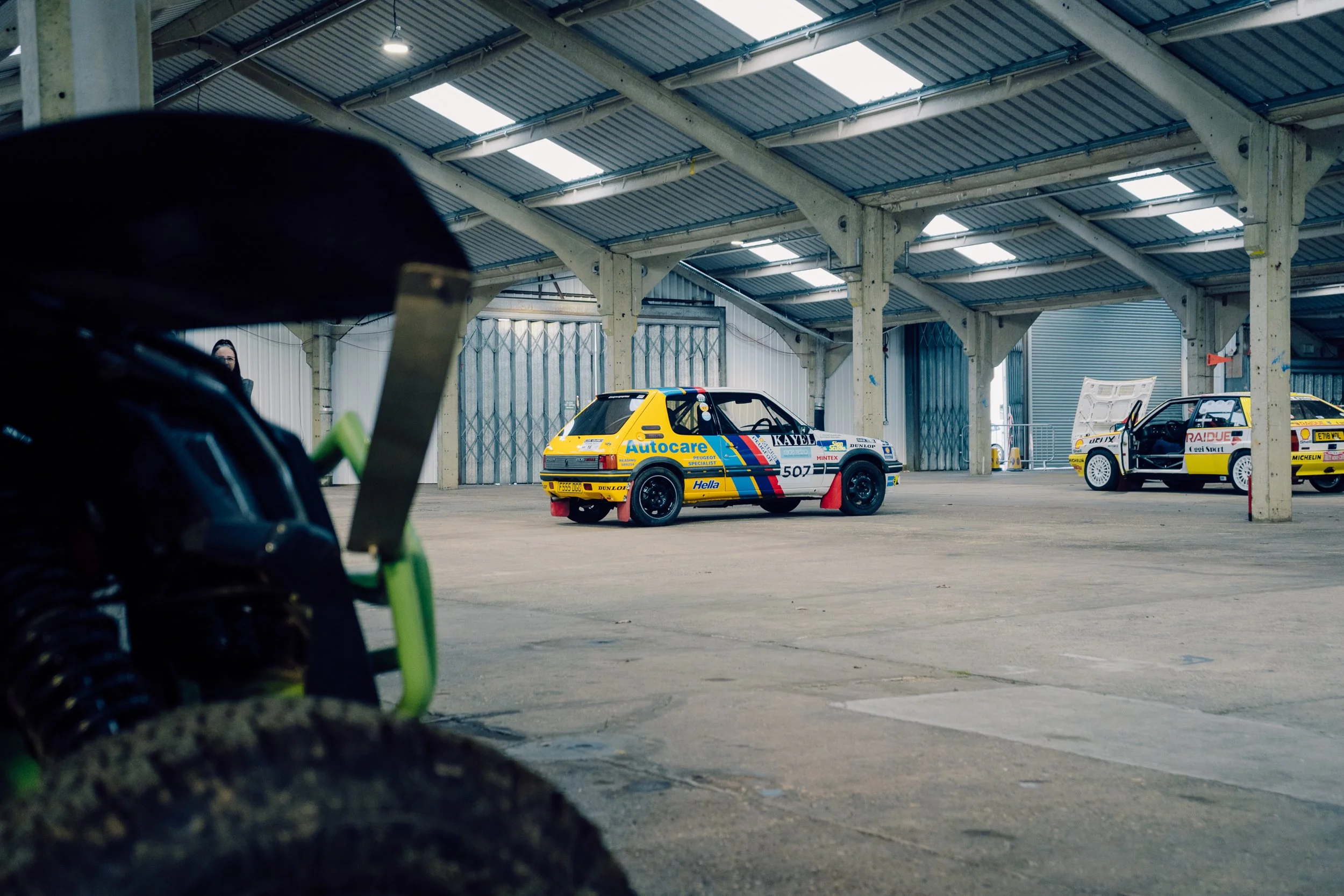 Rally cars parked inside the exhibition hall at Race Retro