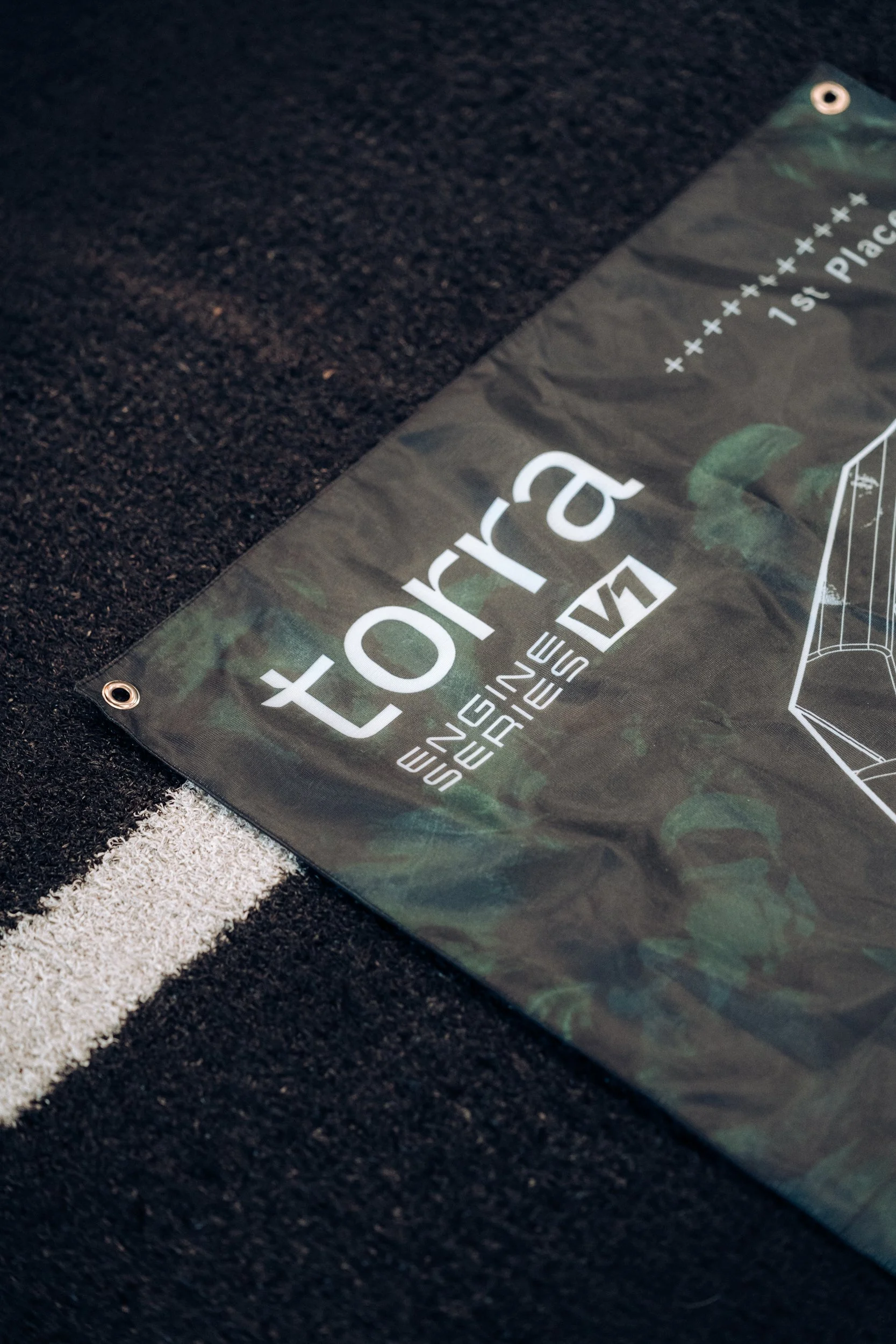 Camouflage Torra Engine Series V1 flag laid on the ground for the Torra Performance campaign