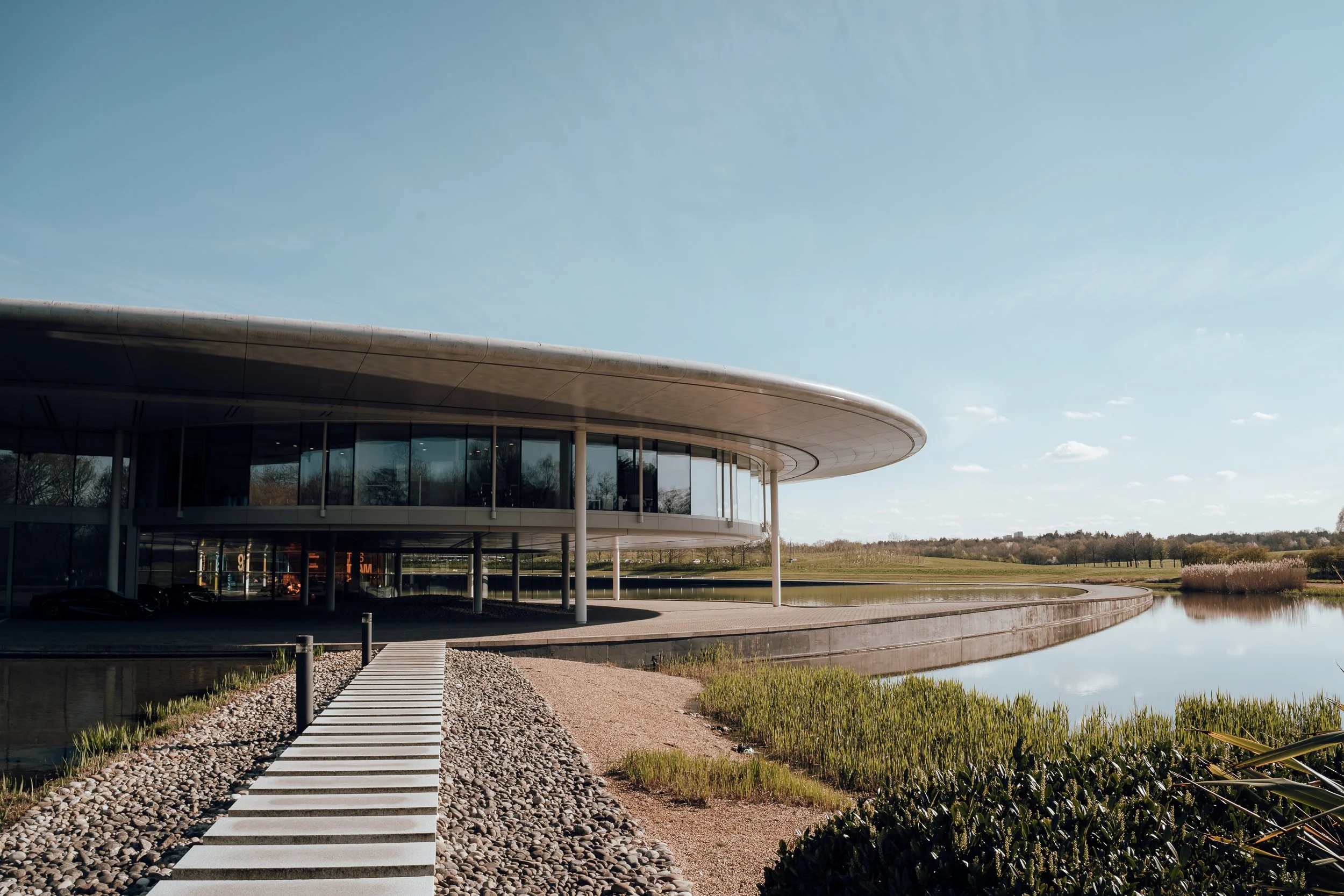 Exterior of the McLaren Technology Centre with its curved glass facade and lake