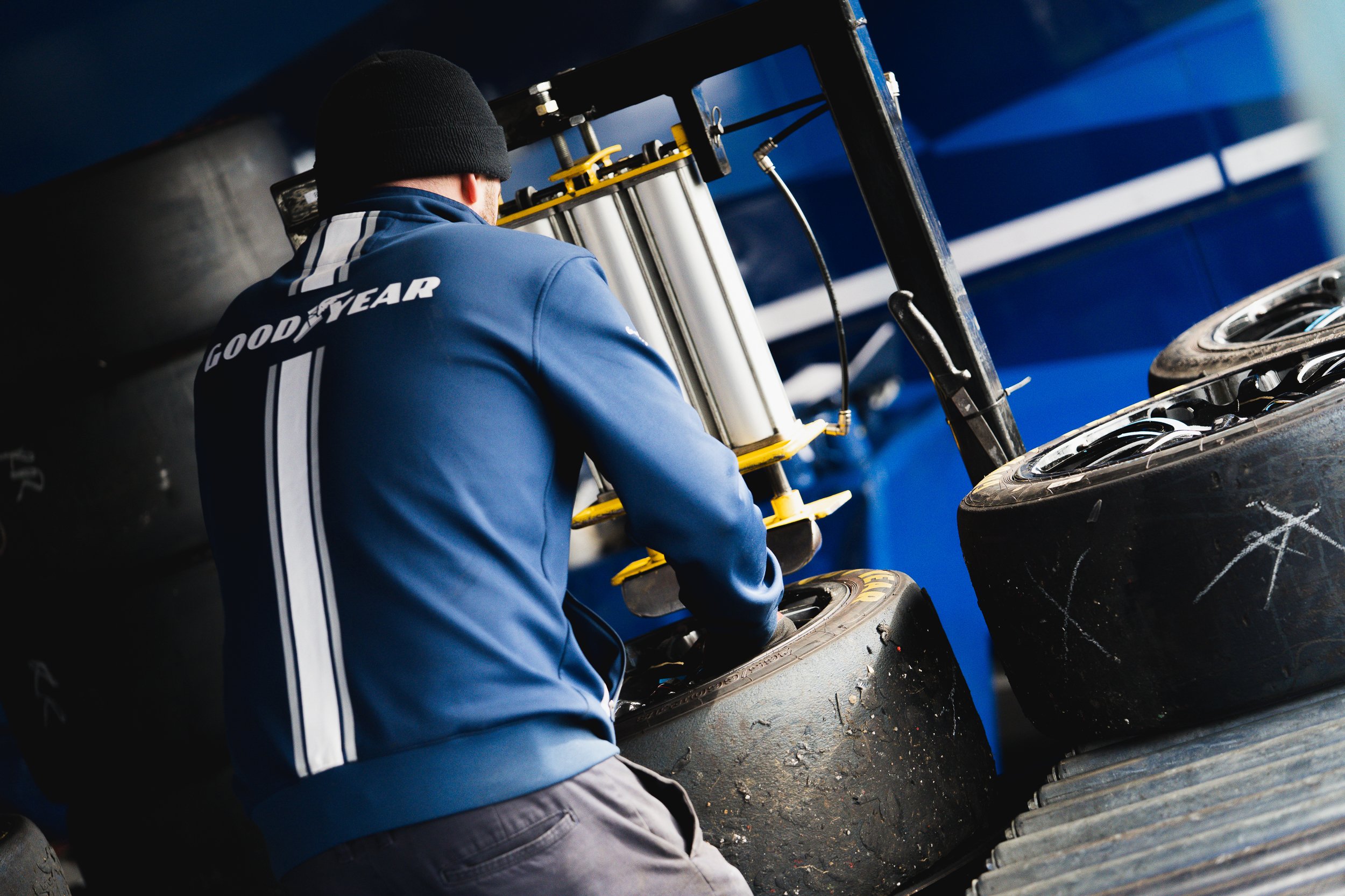 Crew member checking Goodyear tyre stacks in the paddock at Croft testing