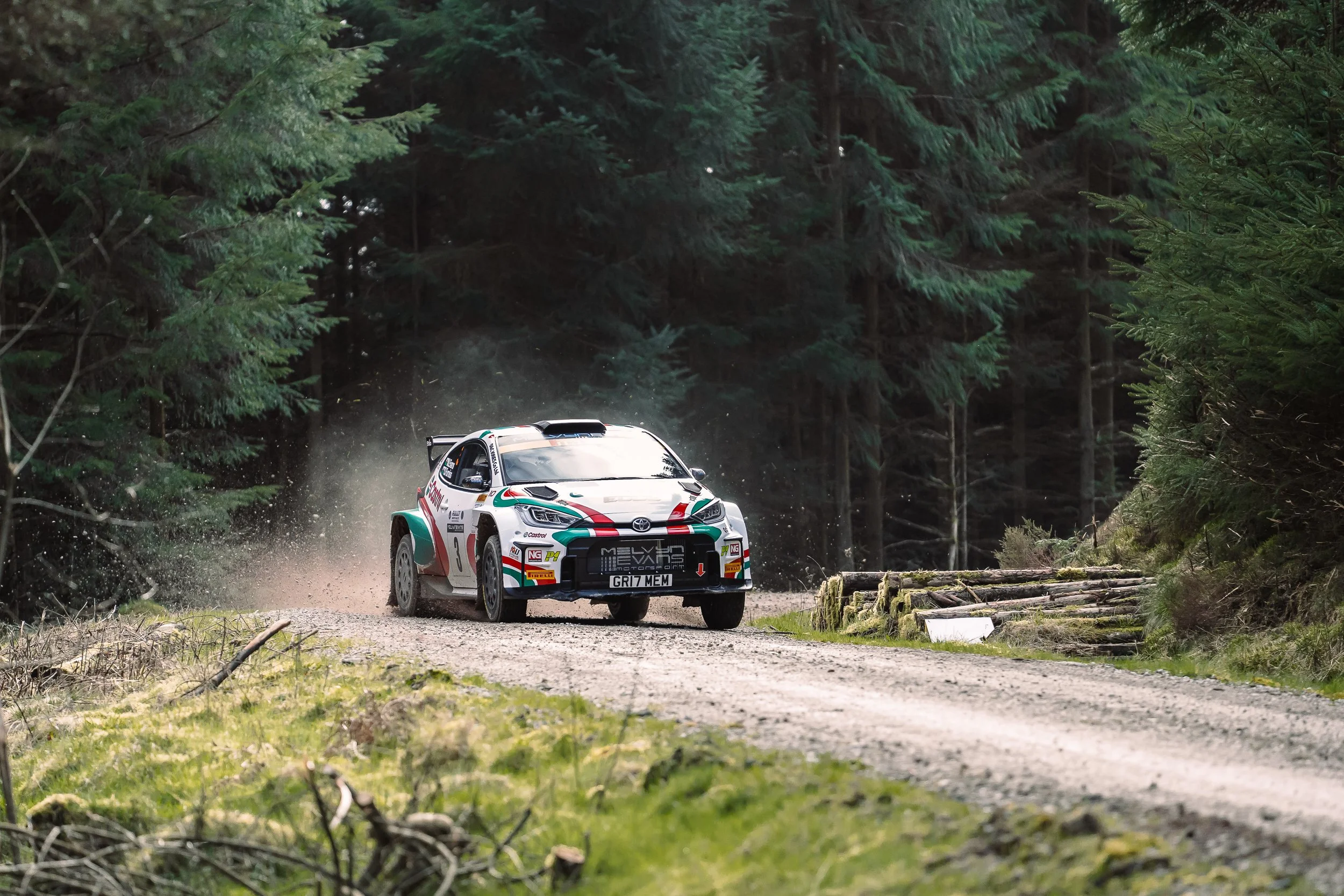 Toyota rally car kicking up gravel dust through a Welsh forest stage at Rally North Wales