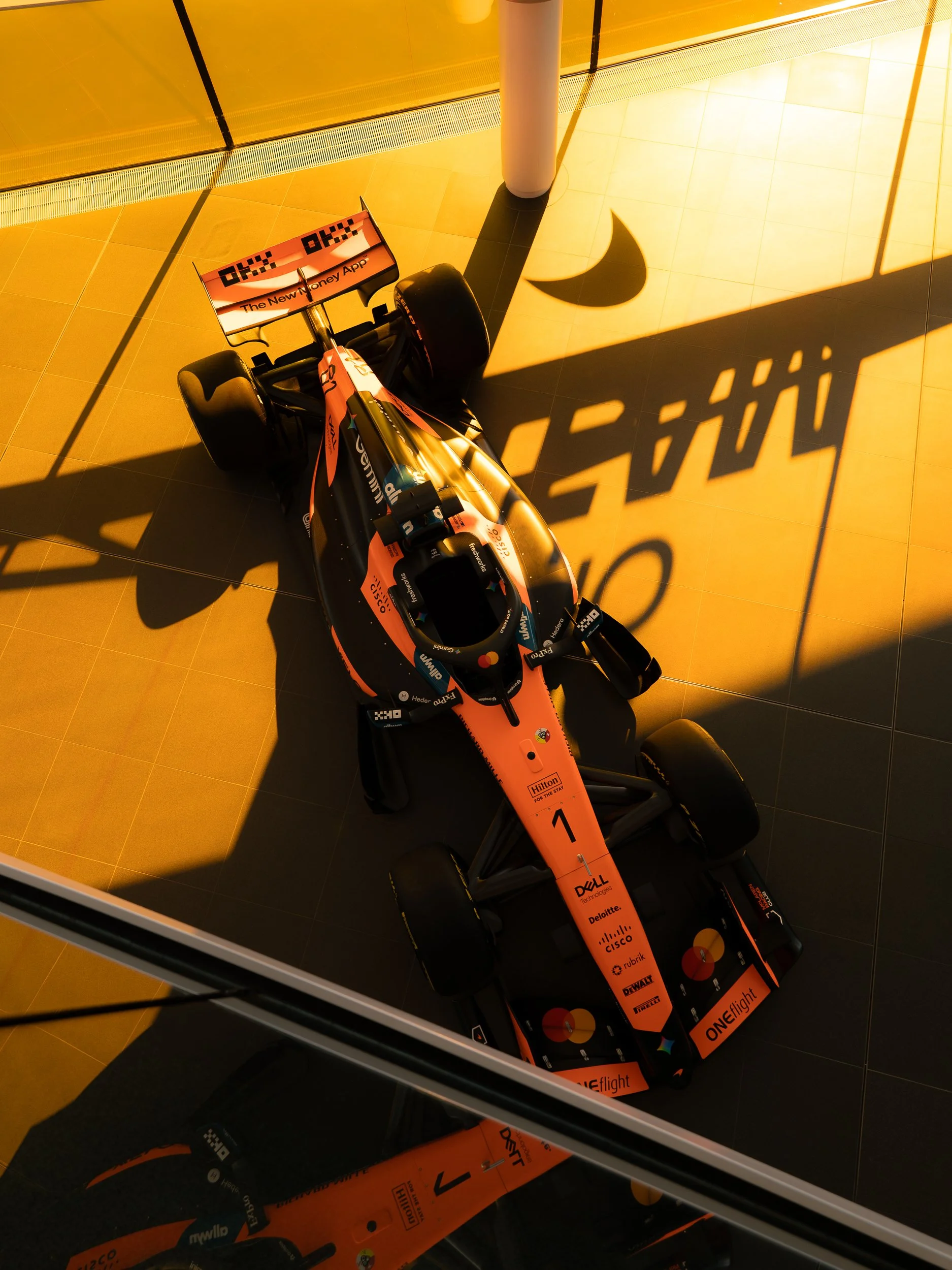 Overhead view of a McLaren Formula One car's nose and front wing with long shadow at the McLaren Technology Centre