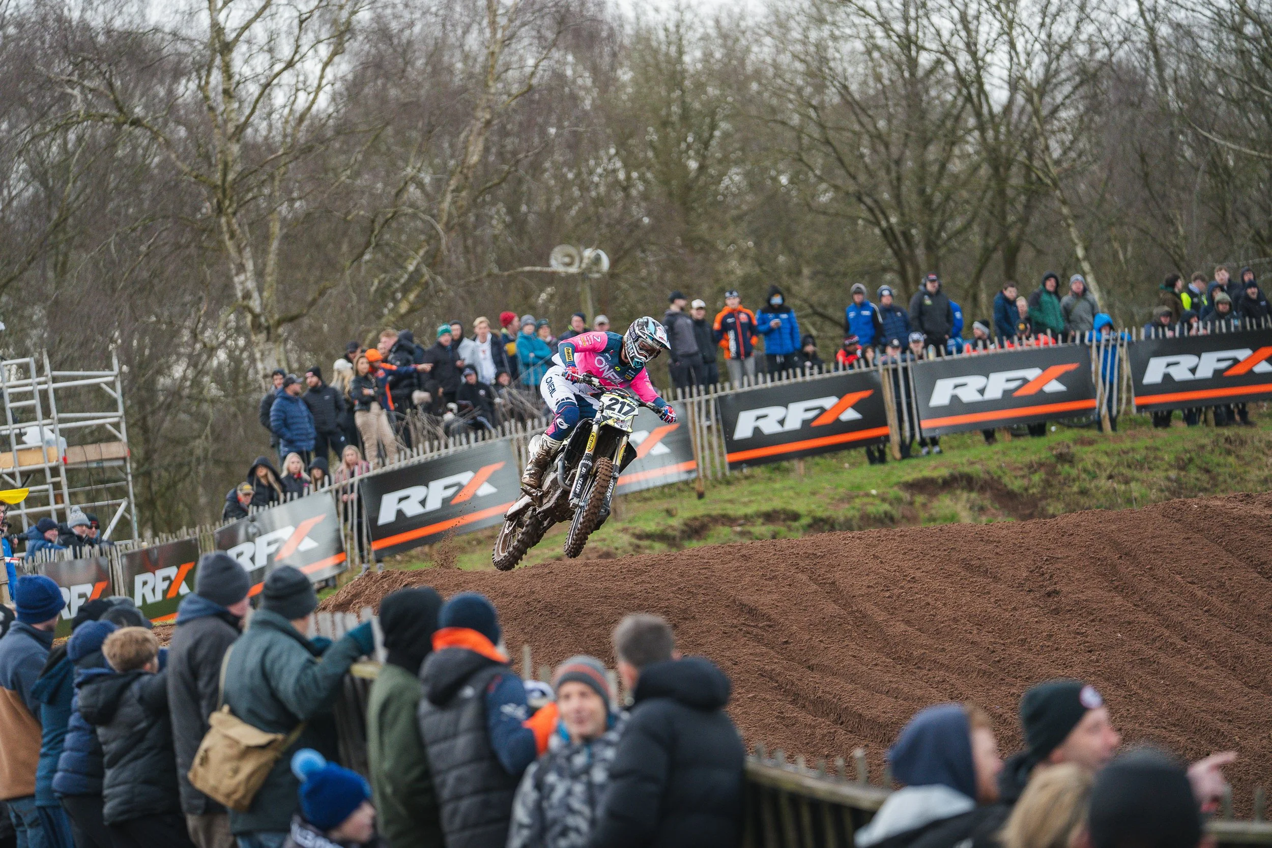 Motocross rider jumping past spectators lining the track at the British Motocross Championship Hawkstone International