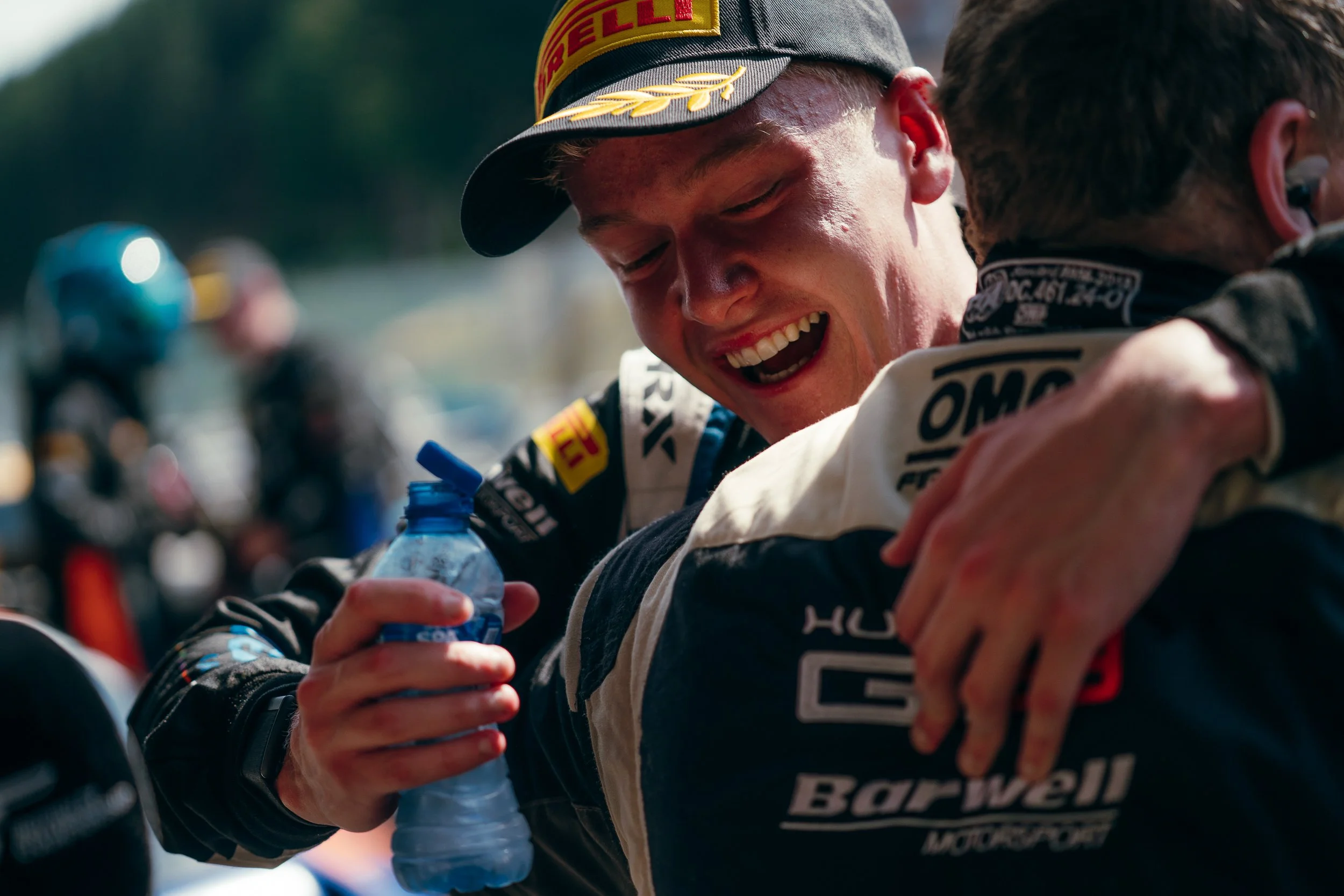 British GT team members celebrating with an embrace in the pit lane at Circuit de Spa-Francorchamps