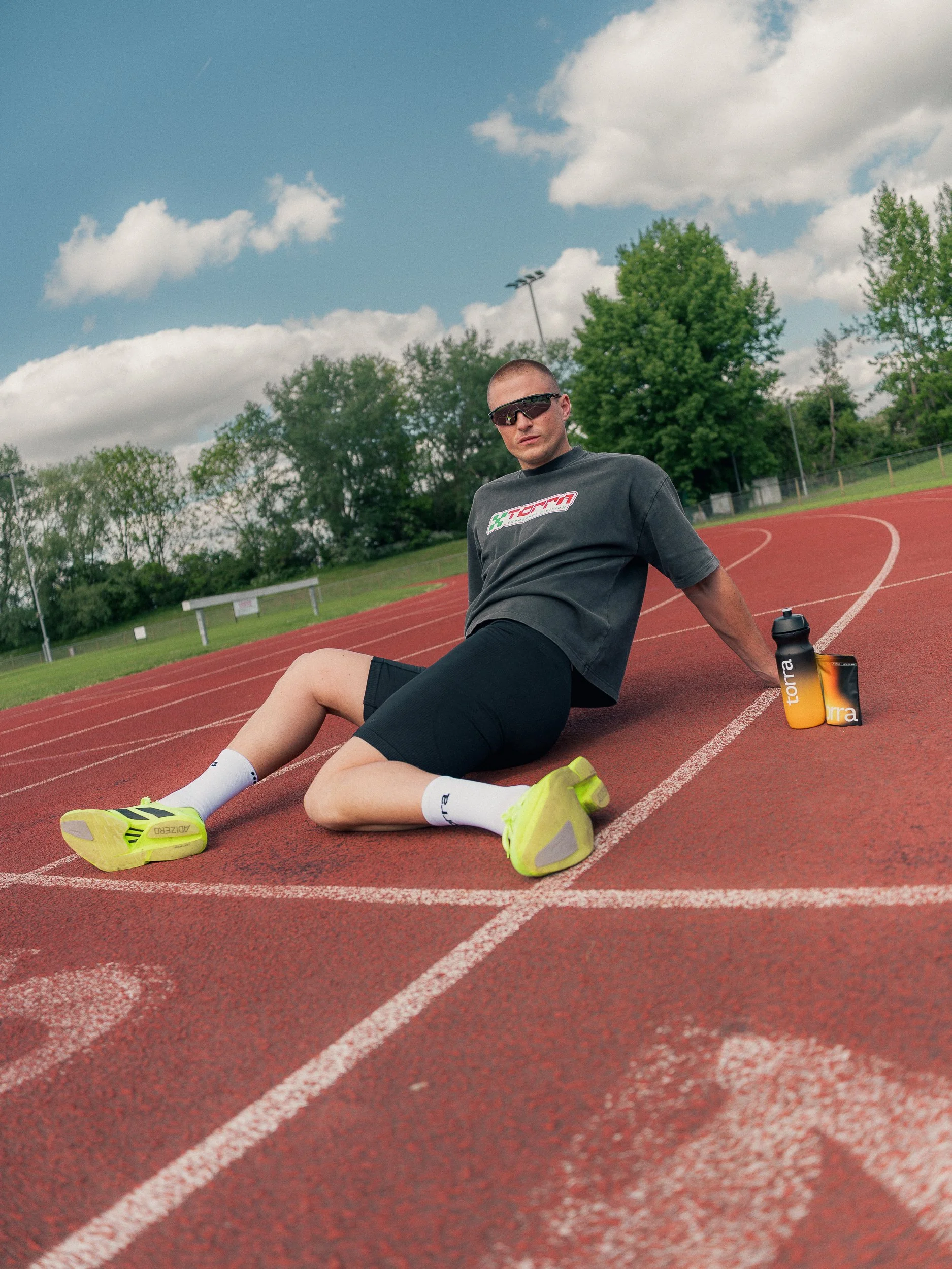 Athlete sitting on the running track wearing sunglasses in Torra kit, Torra Performance Mens Health campaign