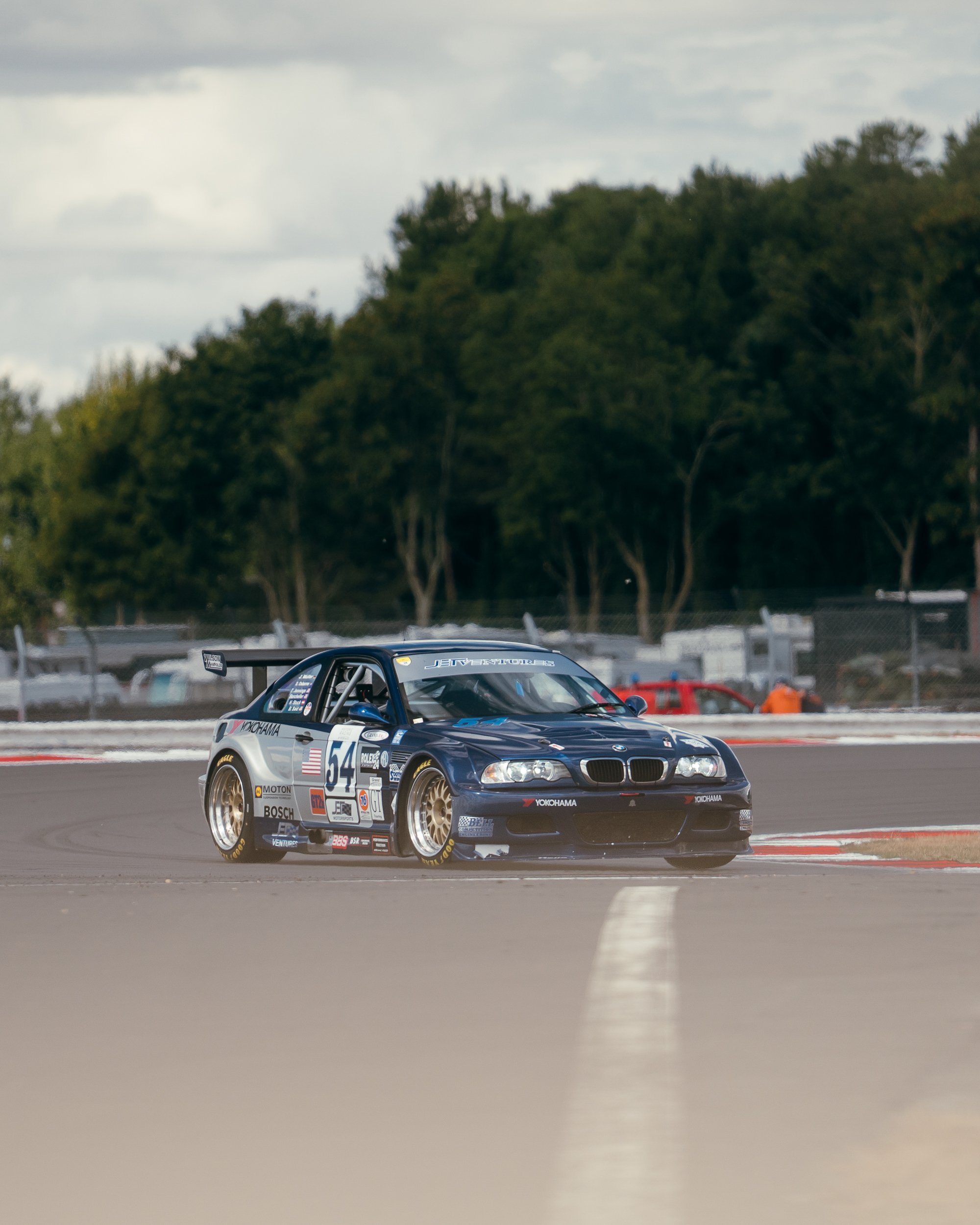 Dark blue touring car cornering on the Silverstone circuit at the BRDC Classic
