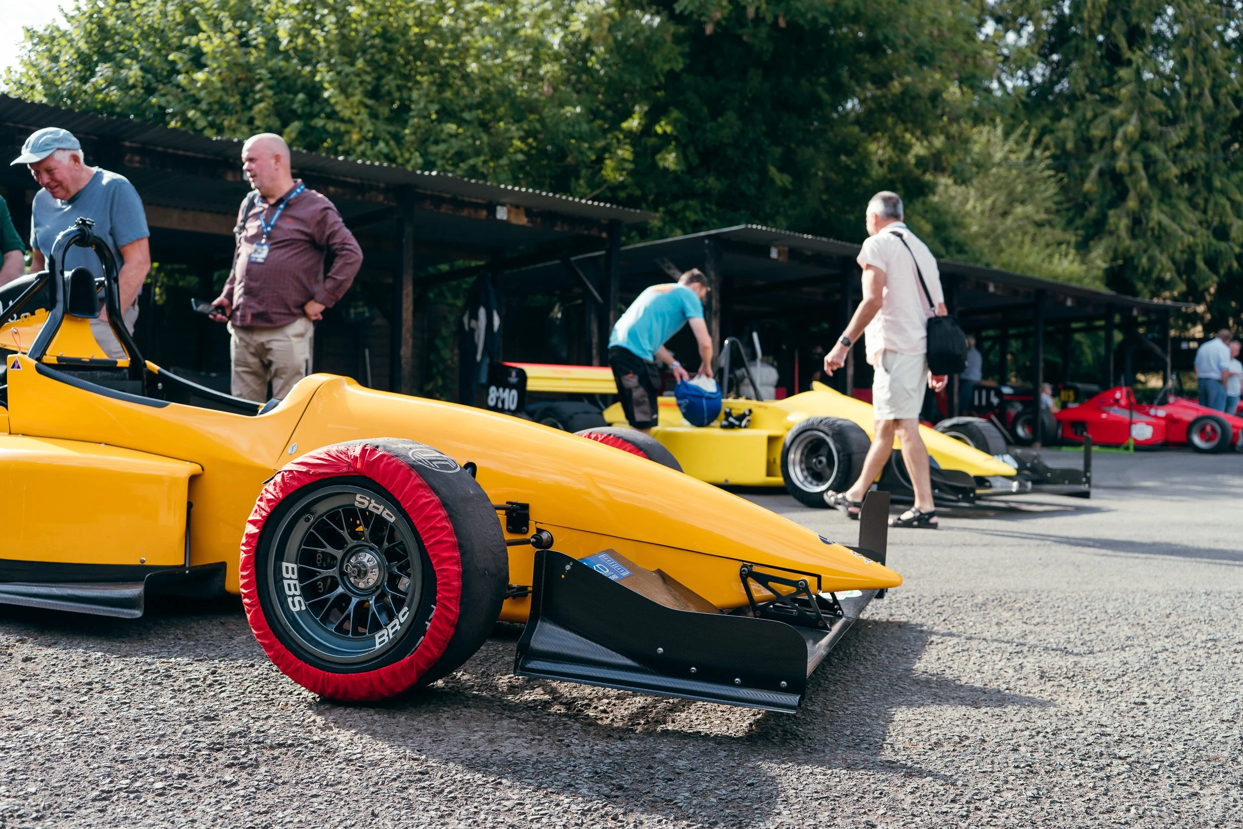 Yellow hill climb single-seater in the paddock with crew preparing cars at Shelsley Walsh Championship Challenge