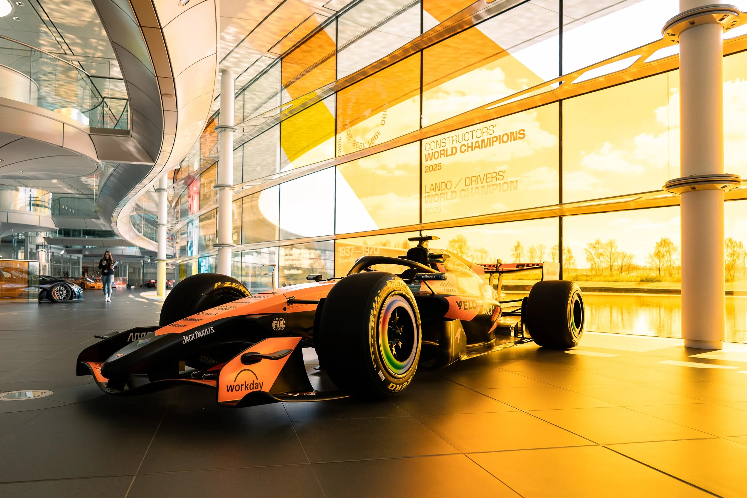 McLaren Formula One car parked inside the glass-walled Boulevard at the McLaren Technology Centre