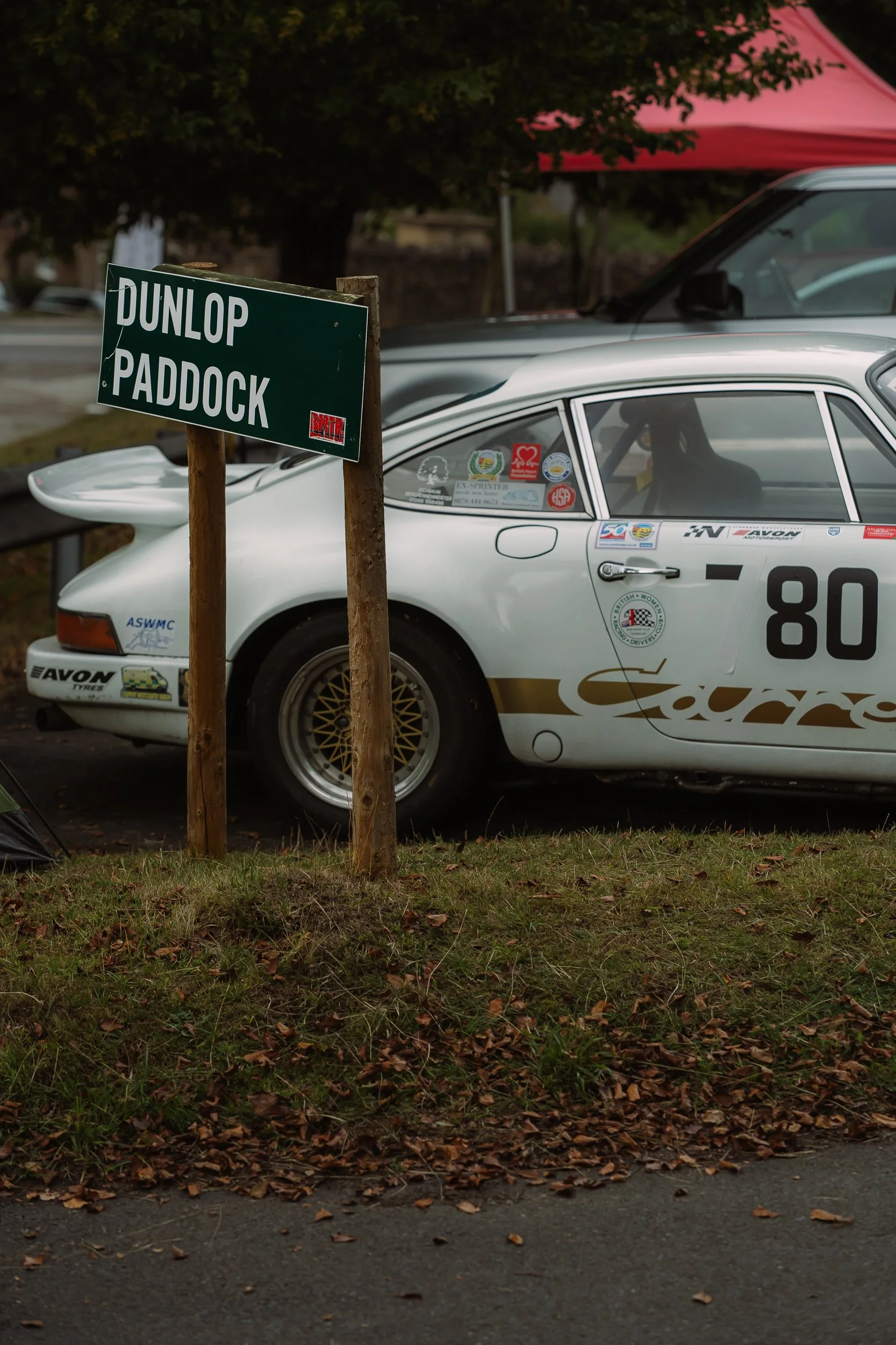 Classic racing car number 80 parked by the Dunlop Paddock sign at Loton Park British Hill Climb Championship