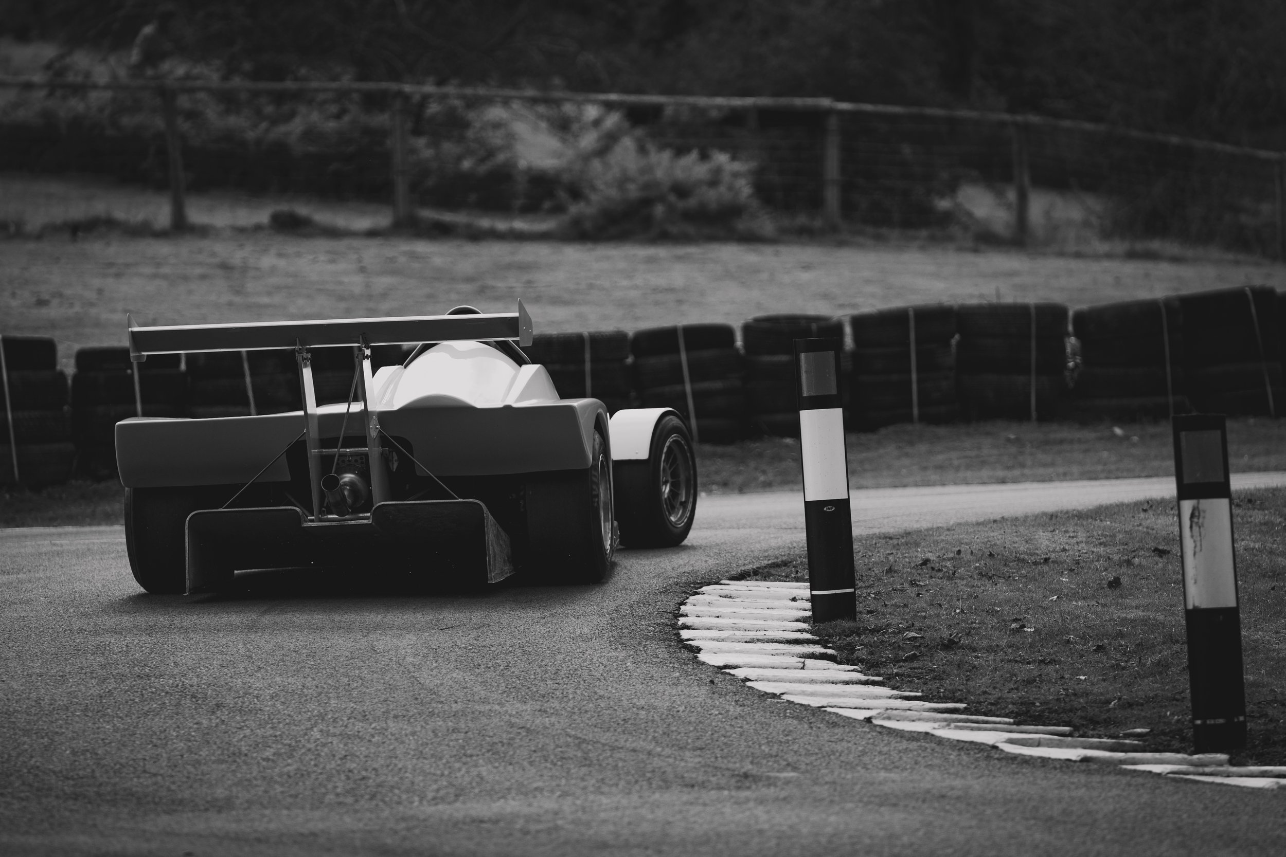 A race car on a racing track, captured from behind, during a race or practice session.