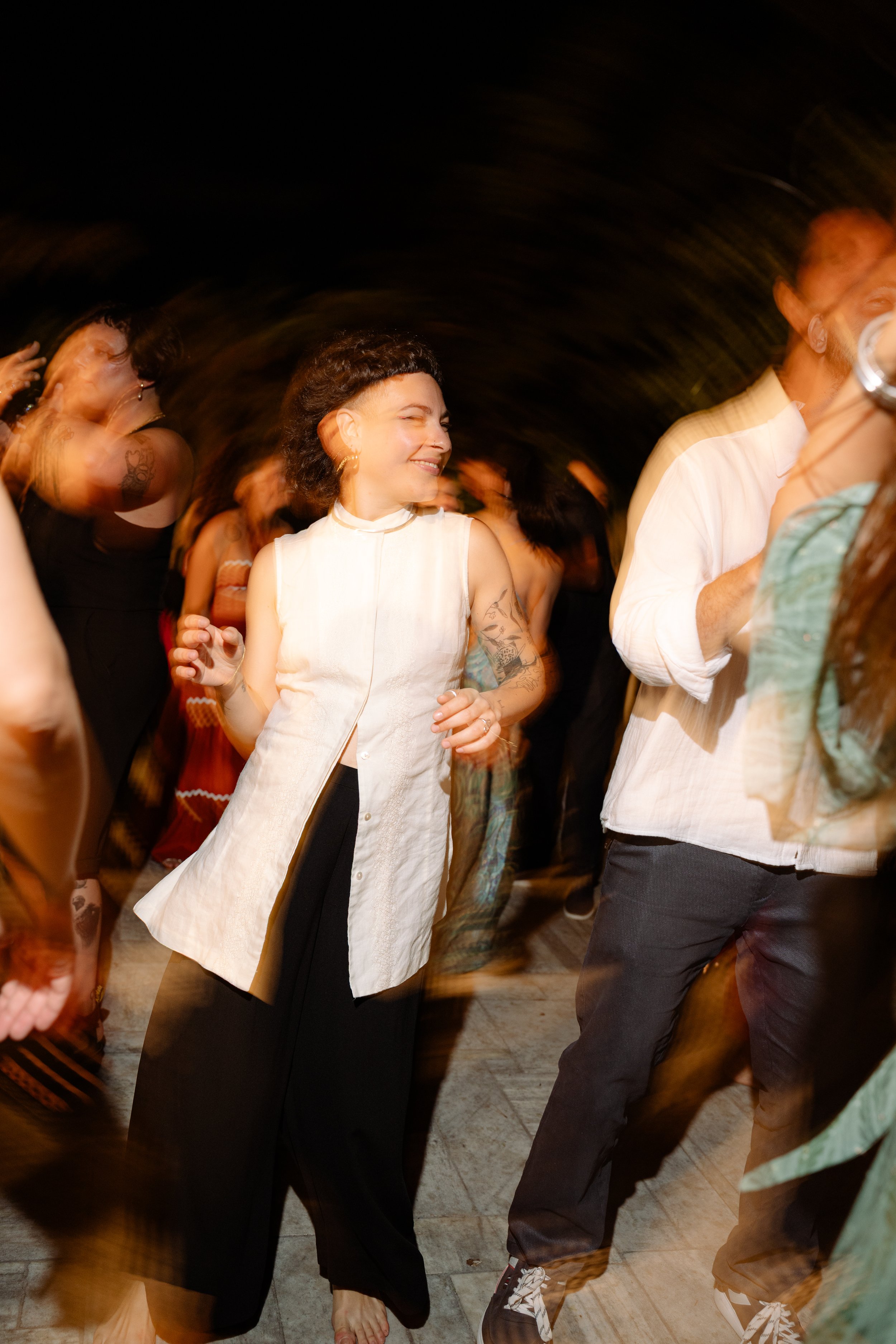 People dancing at an indoor party or event, with blurred motion showing lively movement.