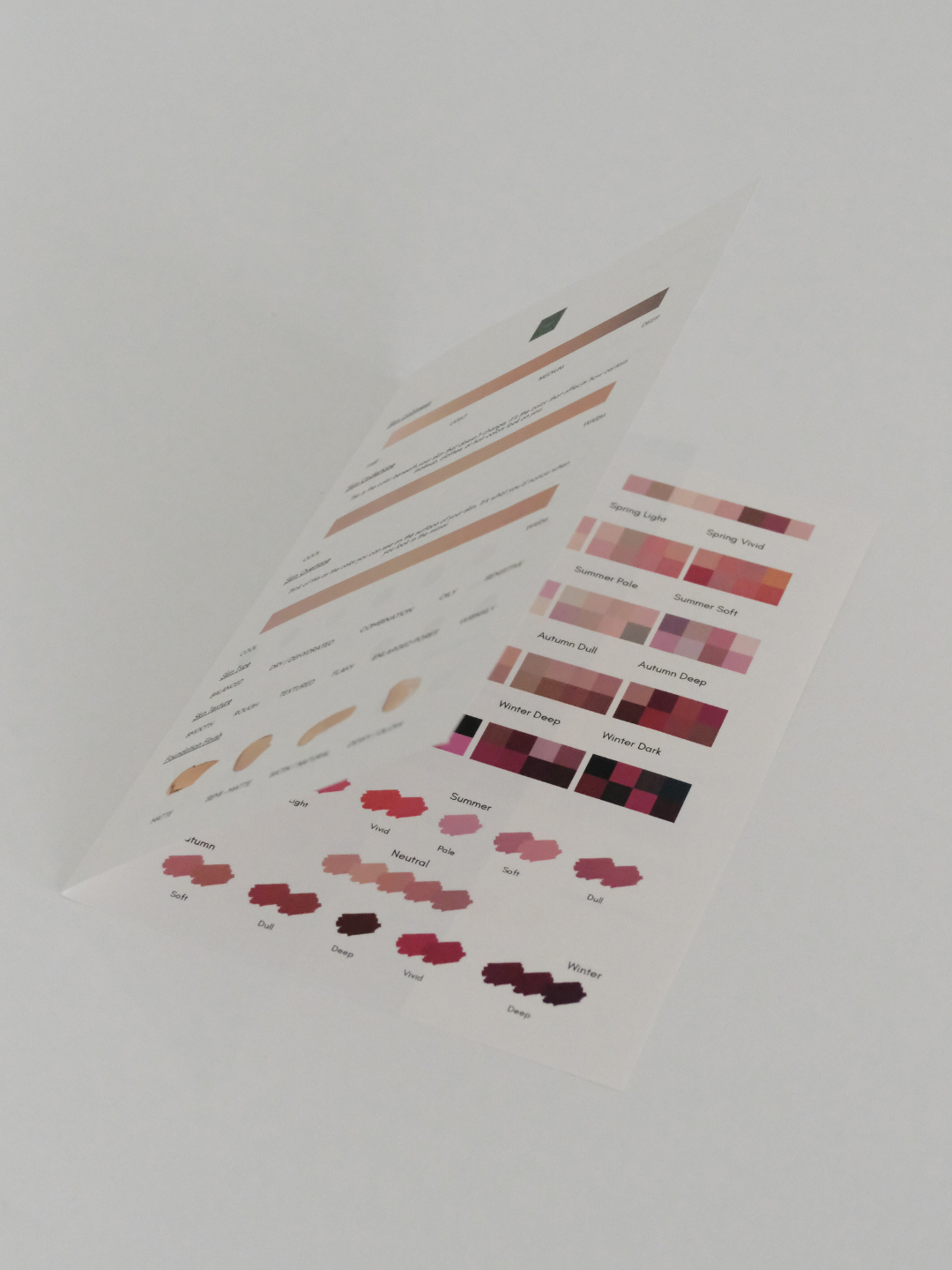 A printed sheet showing various color palettes and swatches, including categories like Summer, Autumn, Winter, and Spring, with labels such as Soft, Deep, Vibrant, and Dull.