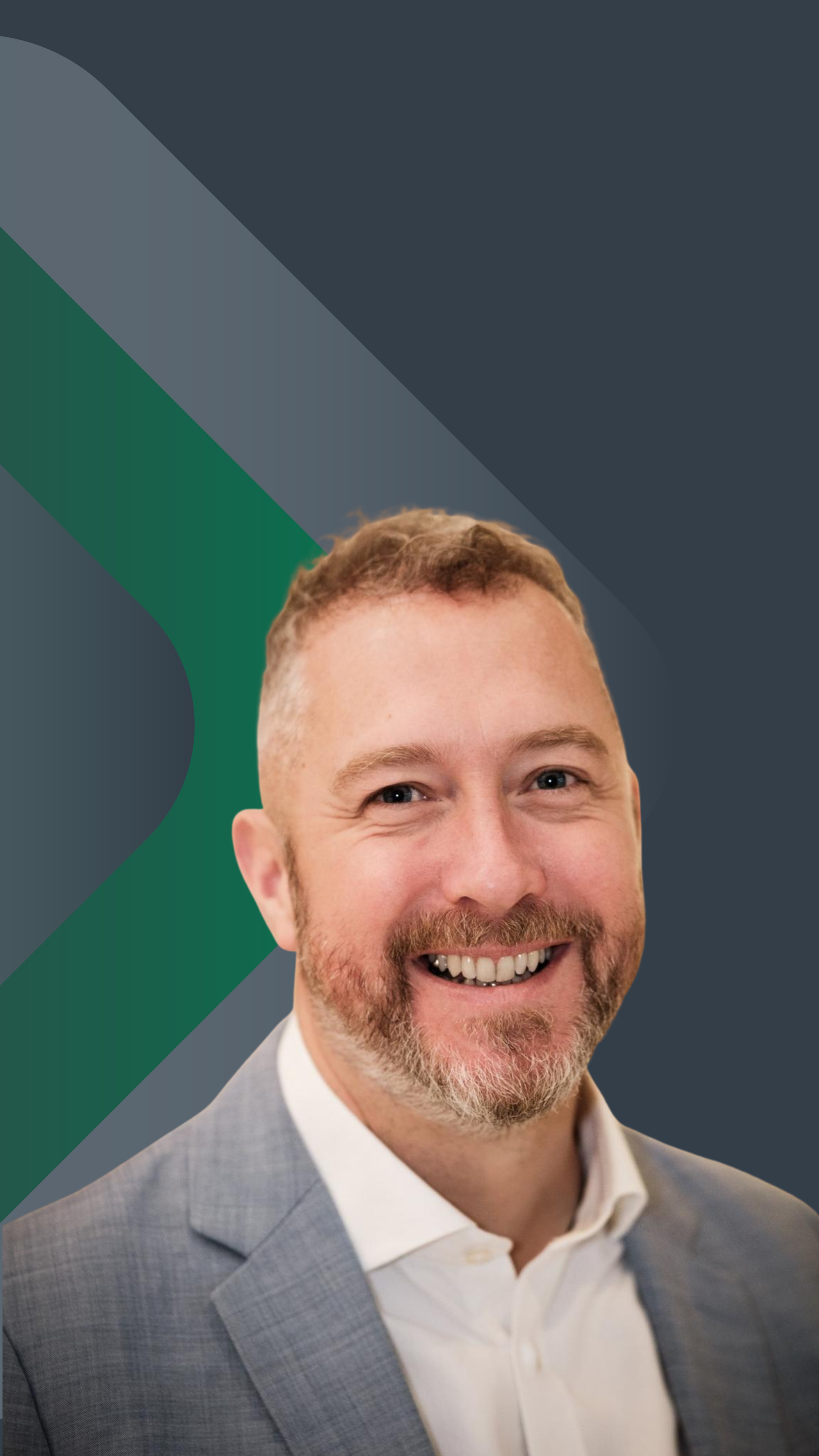 A smiling man with a beard and short hair, wearing a light gray suit and white shirt, standing in front of a dark background with green and blue geometric patterns.