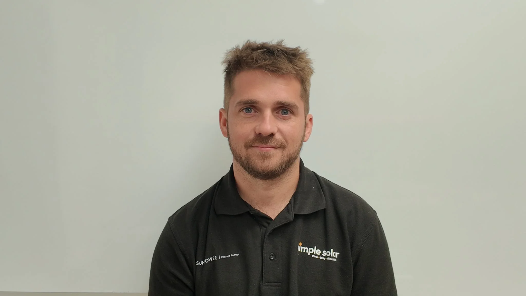 Headshot of Dan Barnes wearing a Simple Solar black polo shirt.