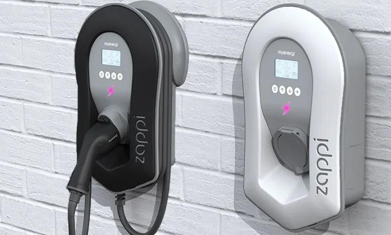 Two Zappi home EV chargers mounted on a brick wall, shown in black and white.