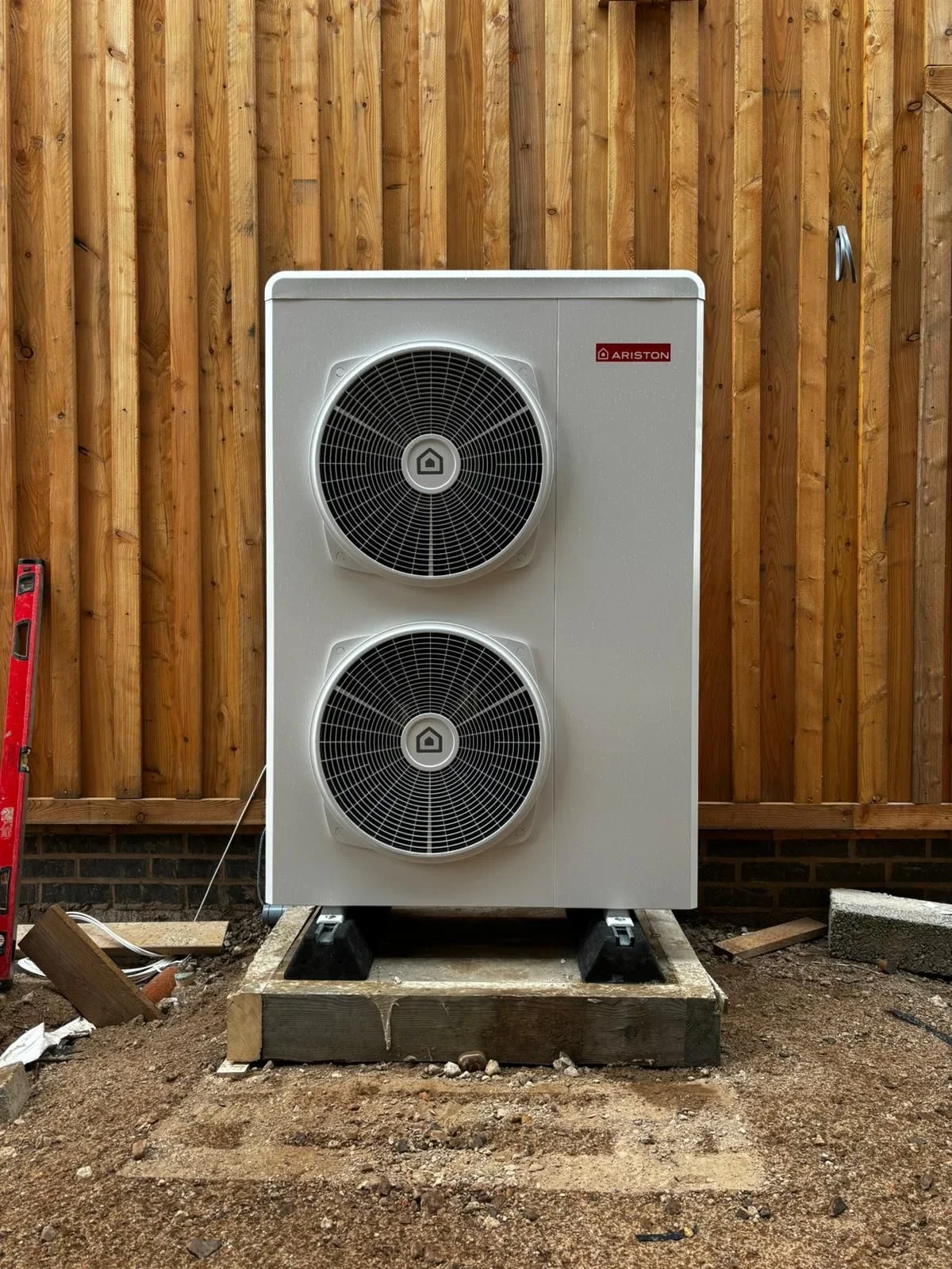 Outdoor heat pump unit installed on a base.