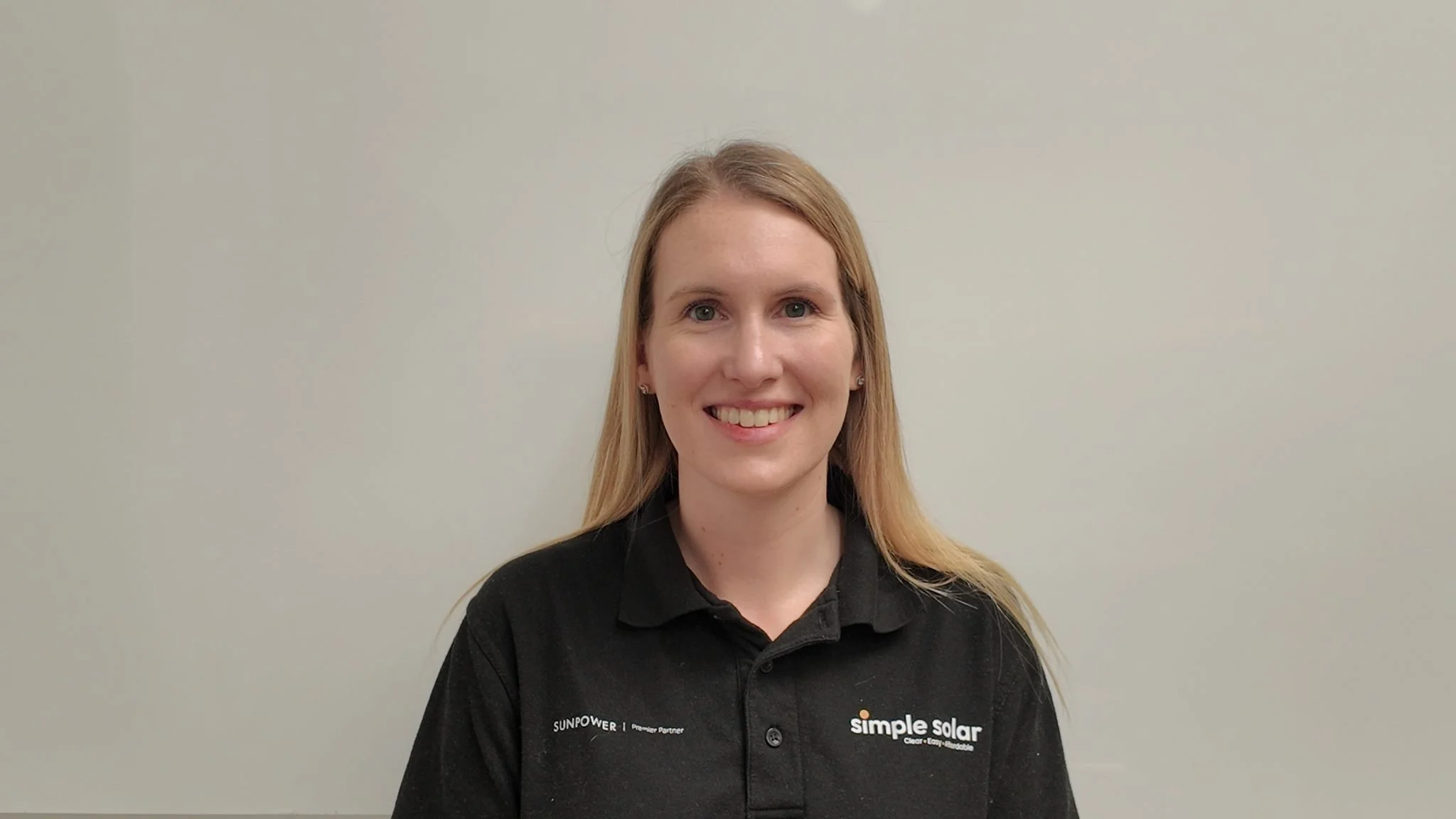 Headshot of a Simple Solar team member Hannah Harvey wearing a black polo shirt.