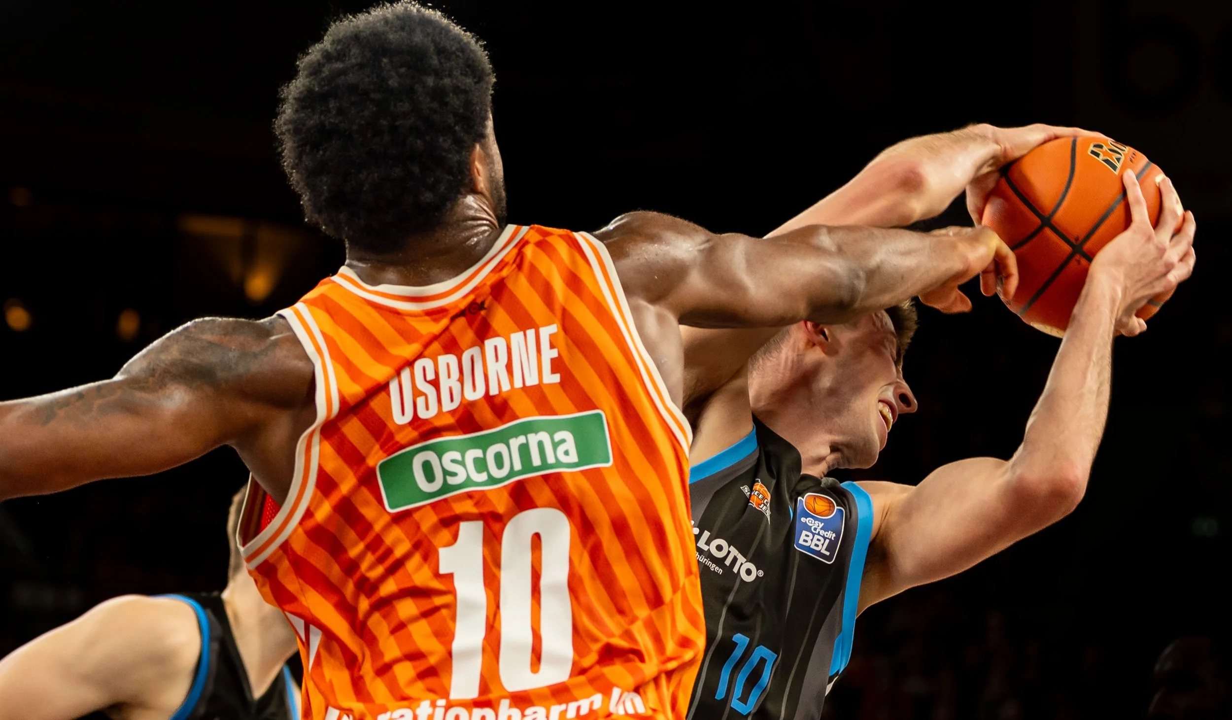 Zwei Basketballspieler im Kampf um den Ball während eines Spiels.