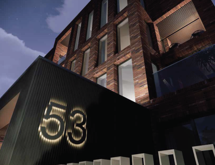 A modern building with a brick facade and large windows, featuring a black exterior wall with illuminated number 53.