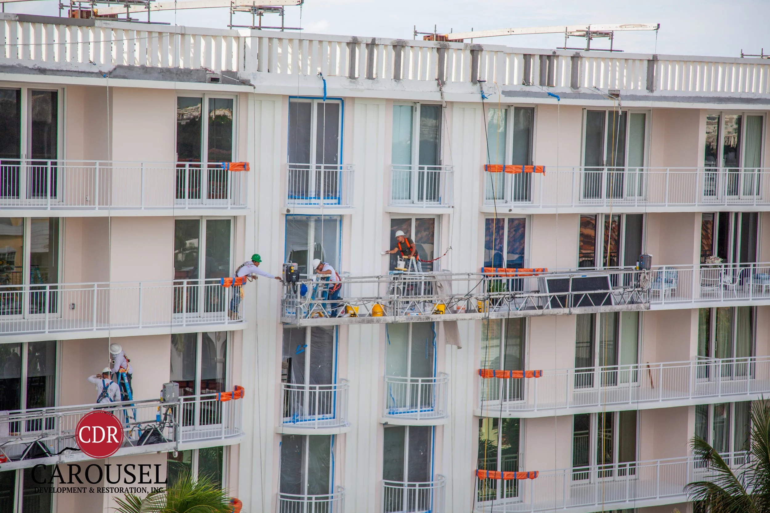 Multiple Carousel employees and scaffolds on the the side of a high rise building