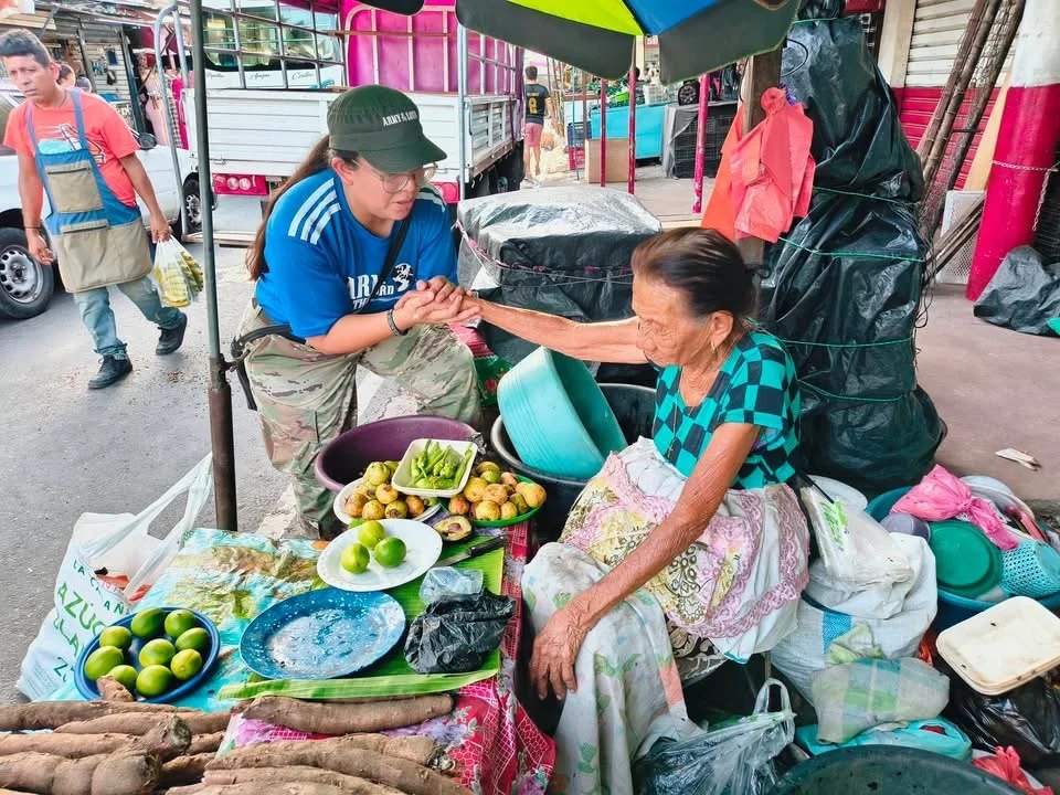 A member of the Zelaya family greets a woman on the street in El Salvador