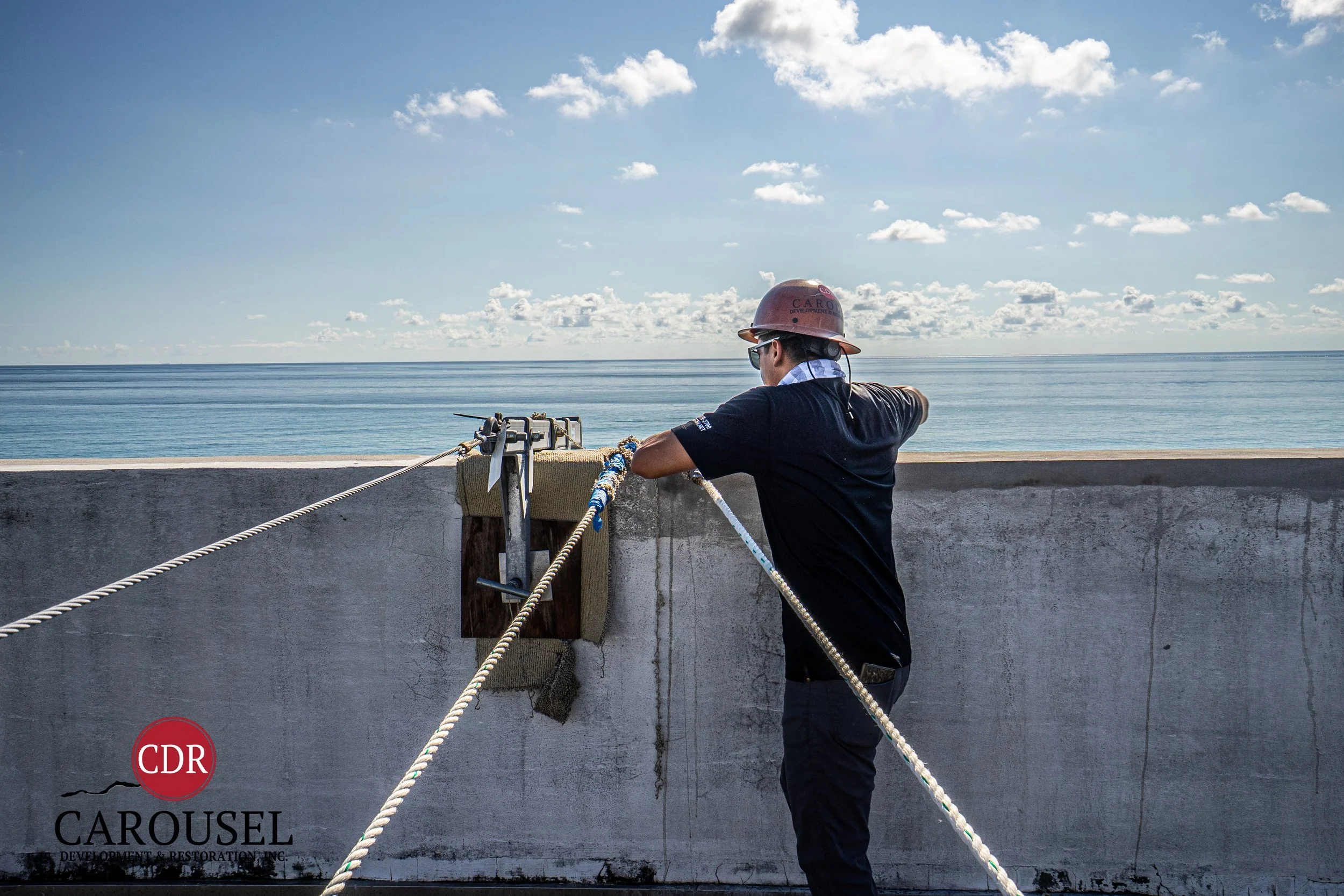 CDRI employee working with ropes on concrete 1/2 wall