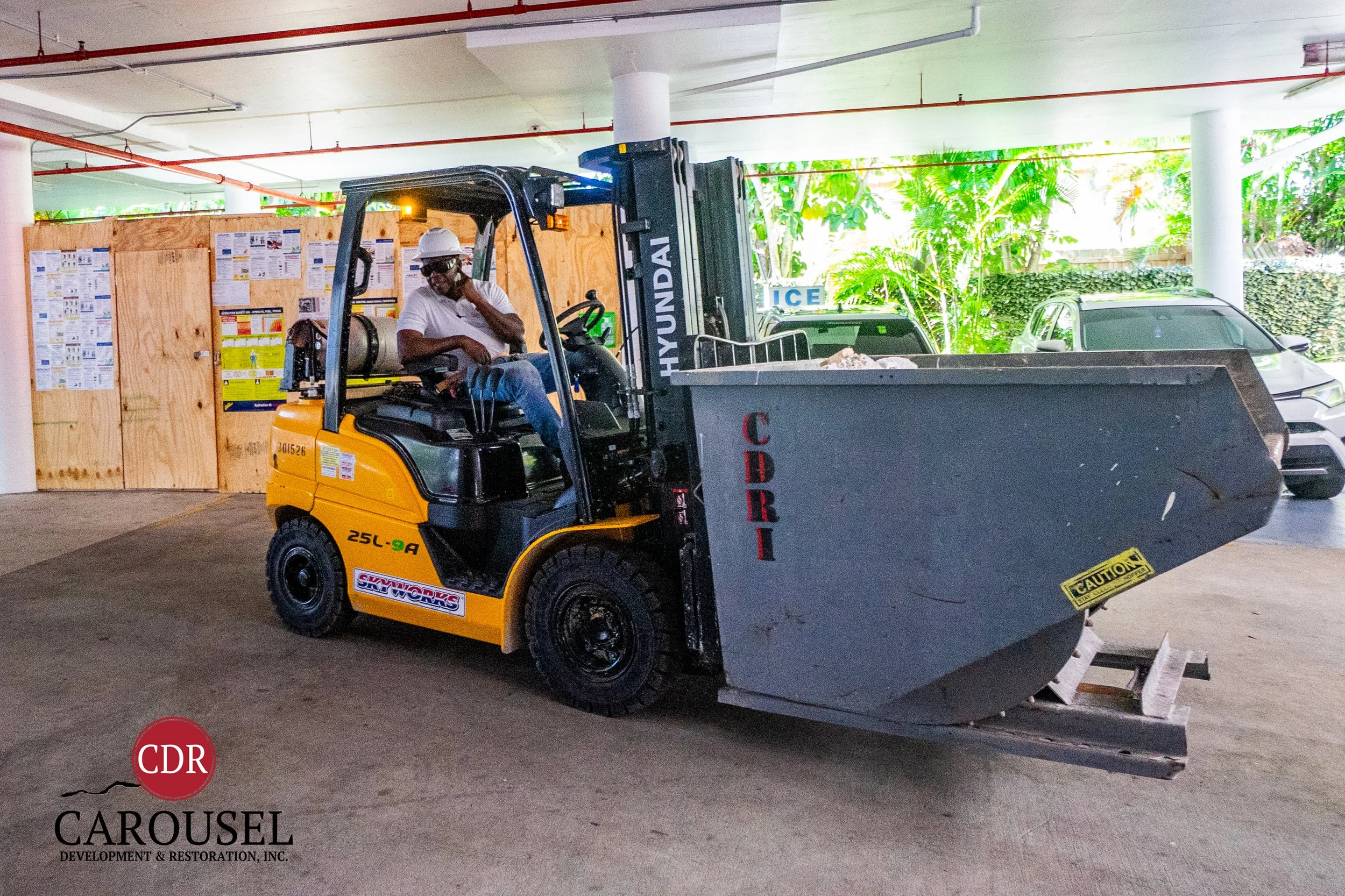 Male Carousel employee on cell phone and operating forklift