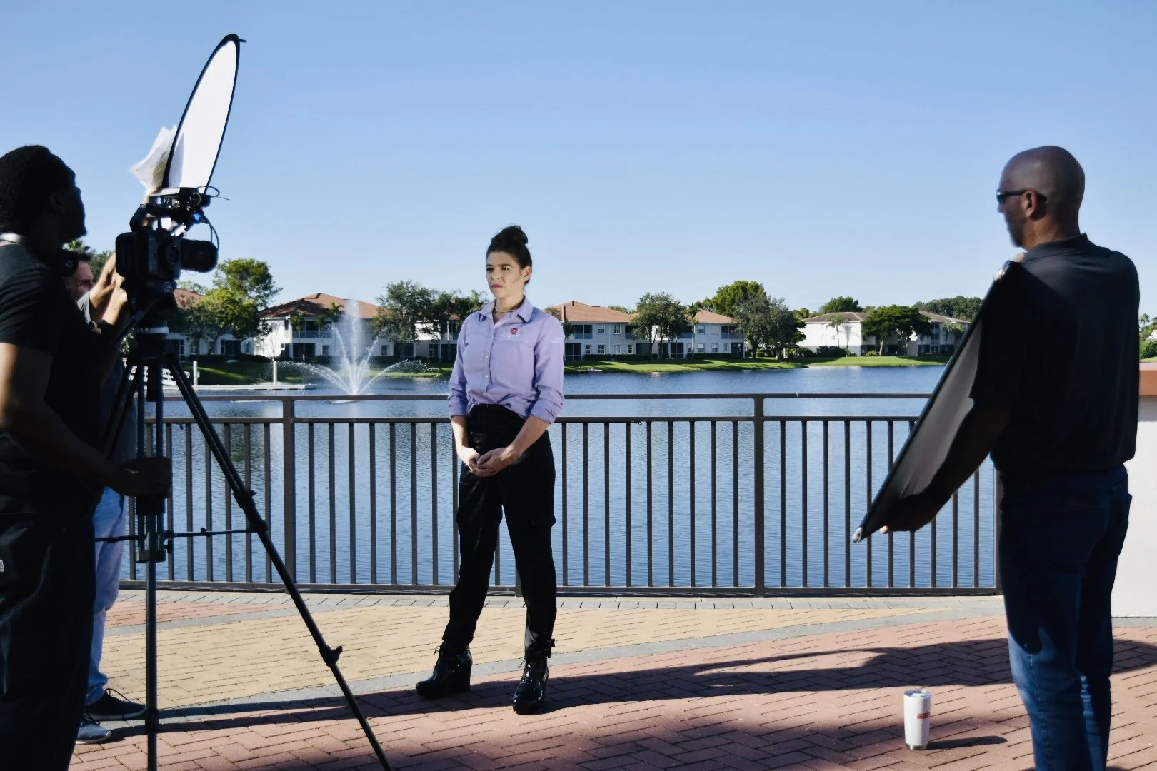 Gabriella Bianchini shooting video on a patio near a lake in a residential community