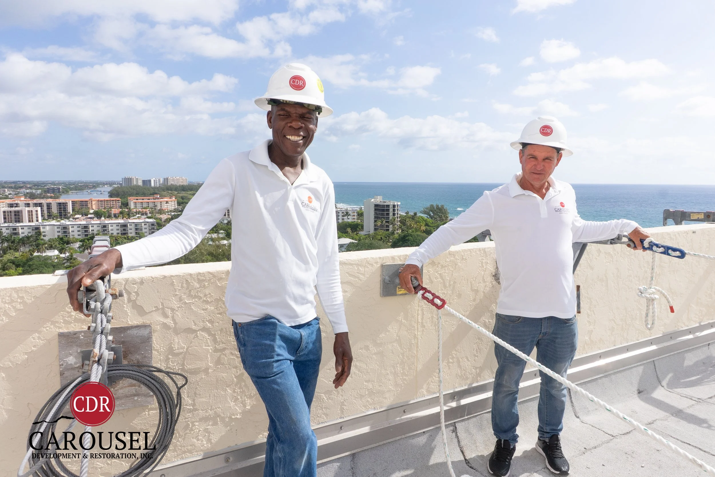 Experienced Foreman, Luncker and Josue perform safety inspections of the swing stage tie back on the roof.  