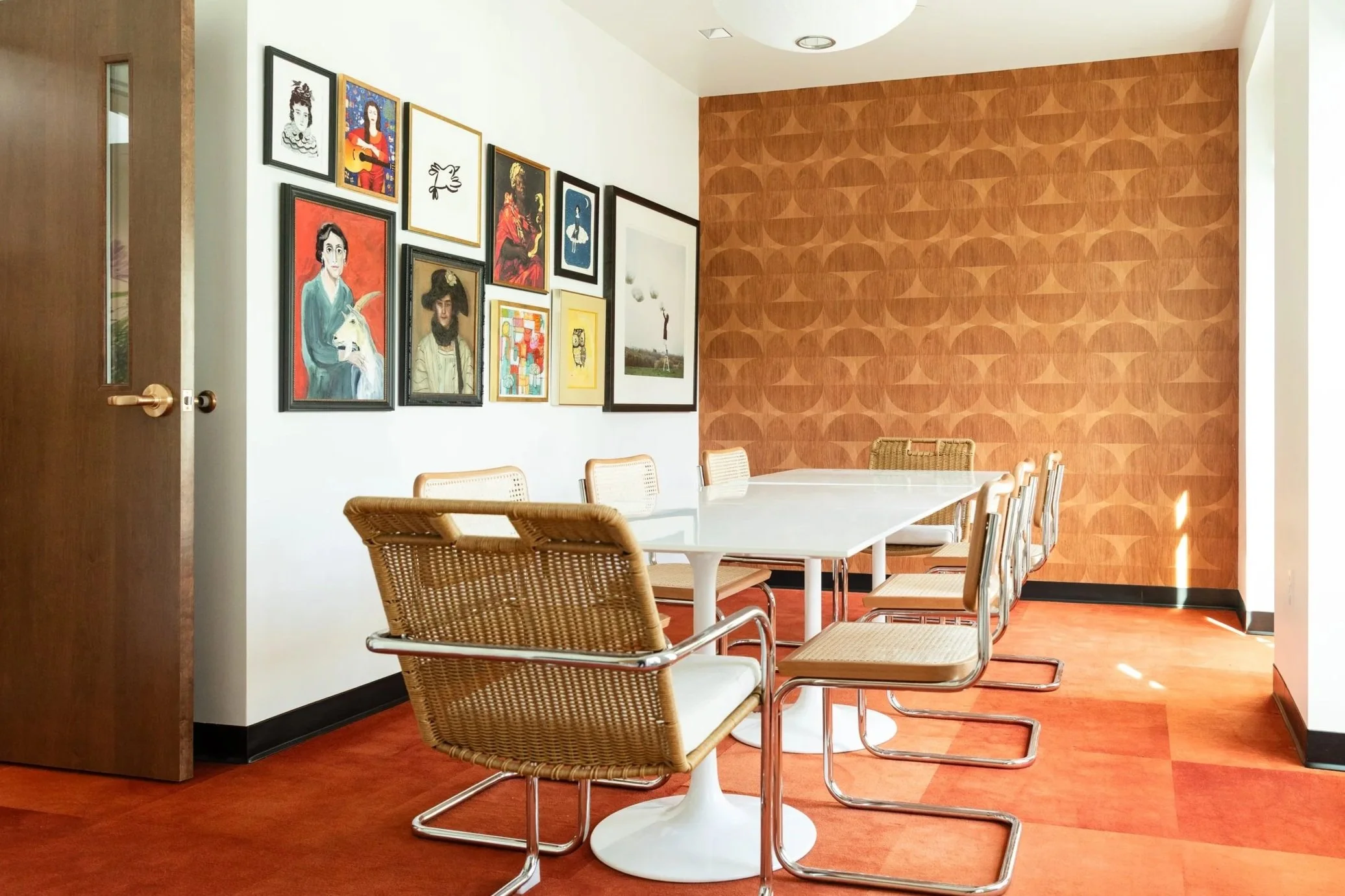 A photograph of a decorative room with a conference table and art on the walls.