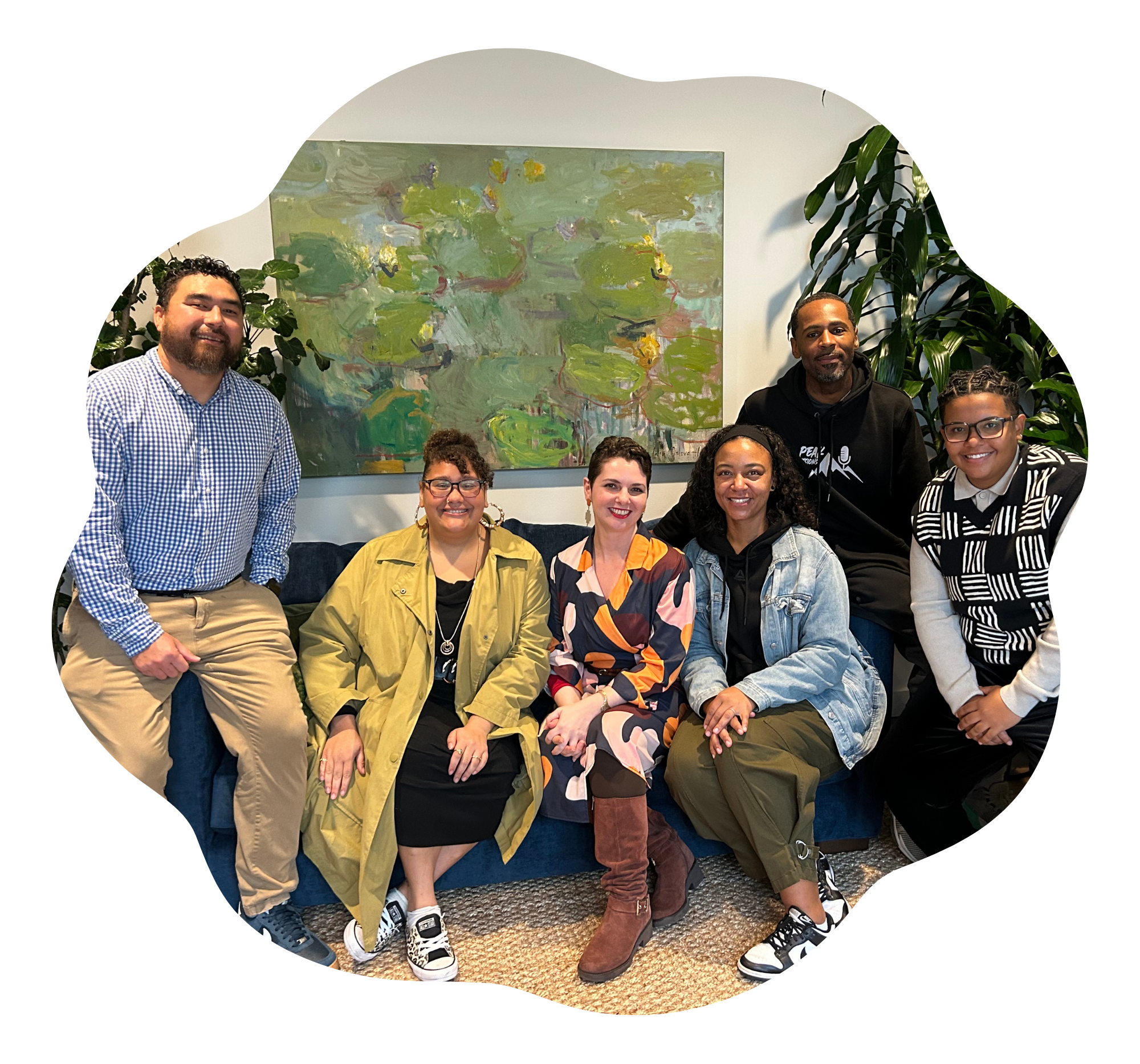 A group of people sitting together, posing, and smiling at The Alcove.